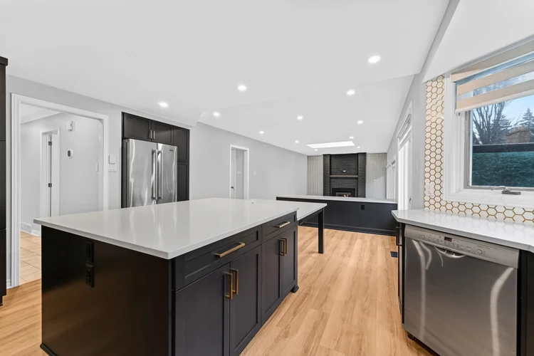 Modern kitchen with an island, dark cabinets and wood floors in NVISION 3D listing photography