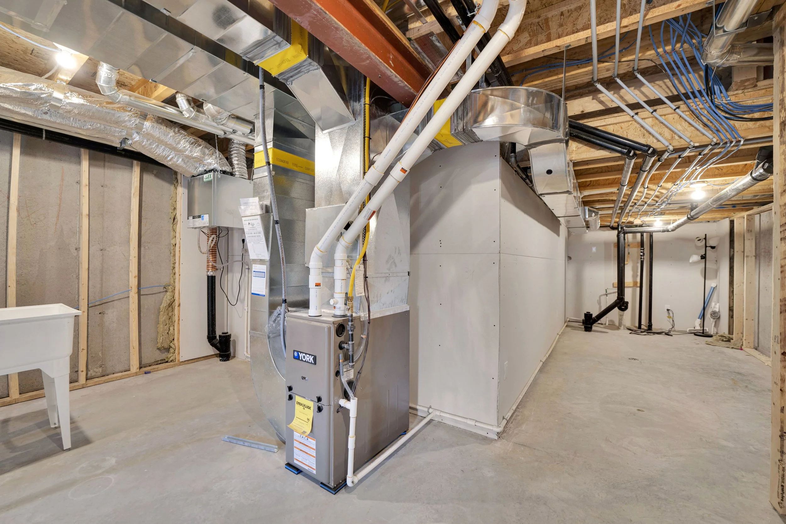 NVISION3D Real Estate Photography Ottawa  Unfinished basement with HVAC system, ductwork, piping, and exposed wooden ceiling joists.