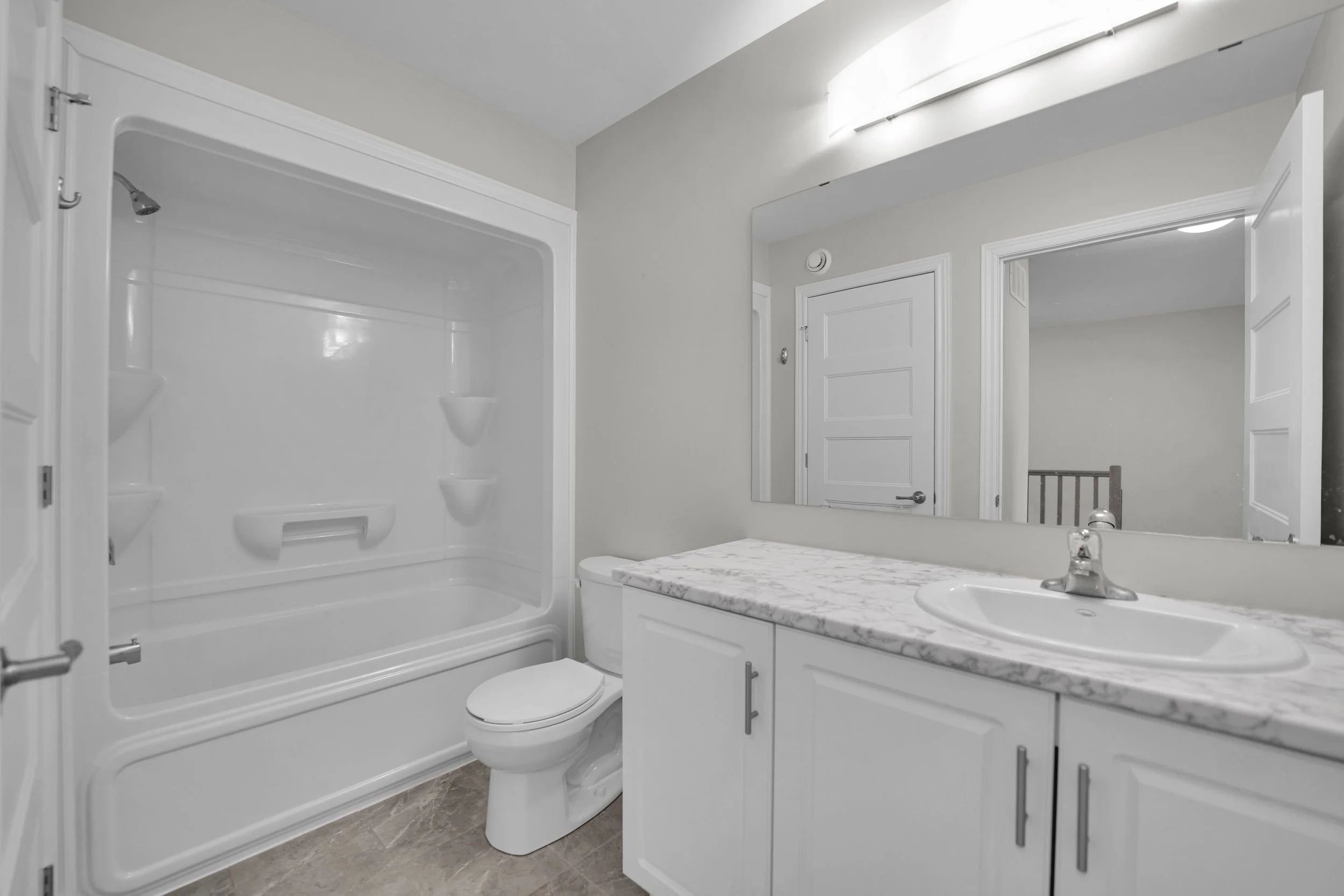 NVISION3D Real Estate Photography Ottawa  A clean, modern bathroom with a white shower stall, a toilet, a white vanity with a marble countertop, a mirror, and a large overhead light fixture.