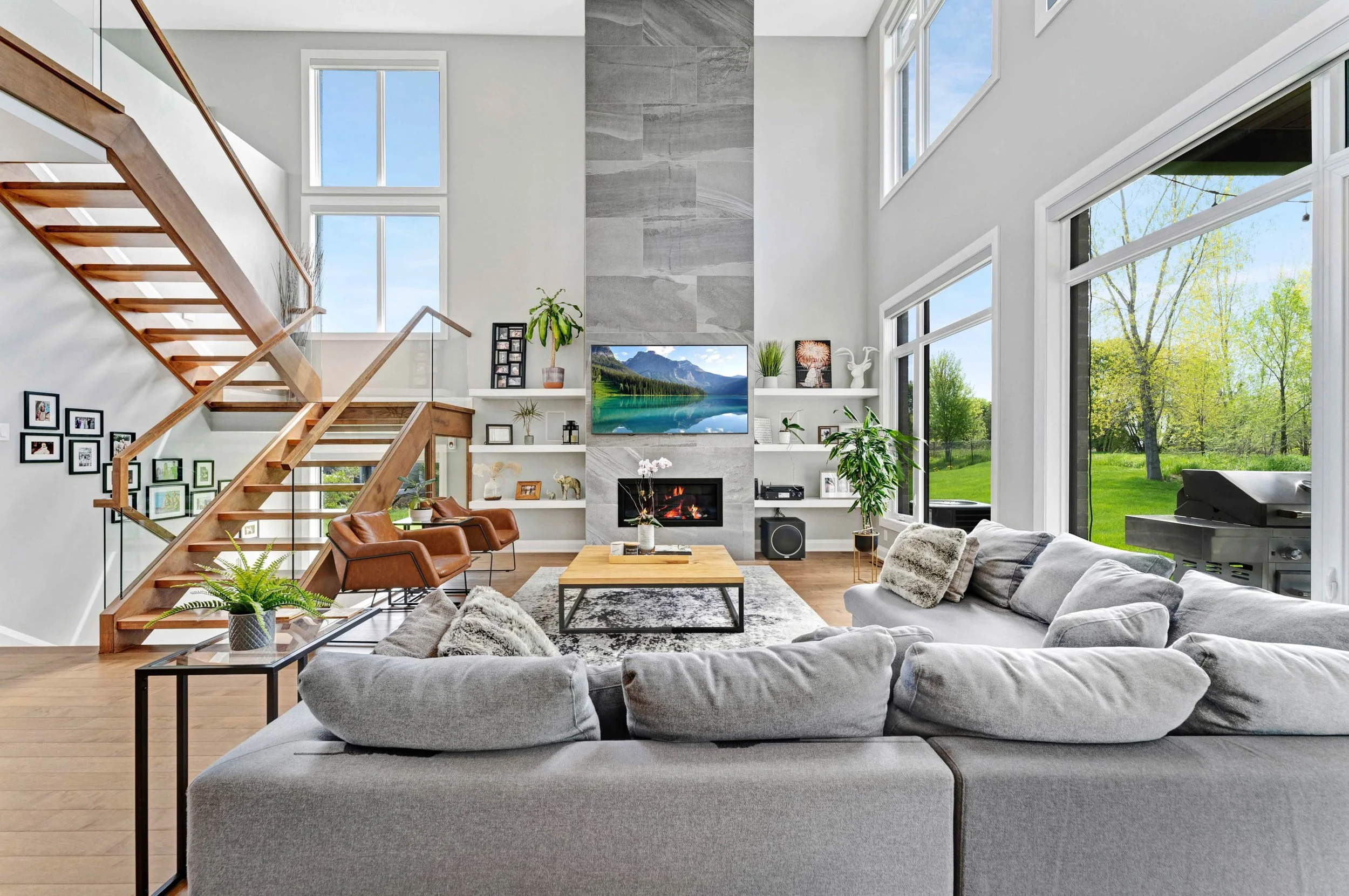 Bright open-concept living room with a fireplace, tall windows and a sectional sofa
