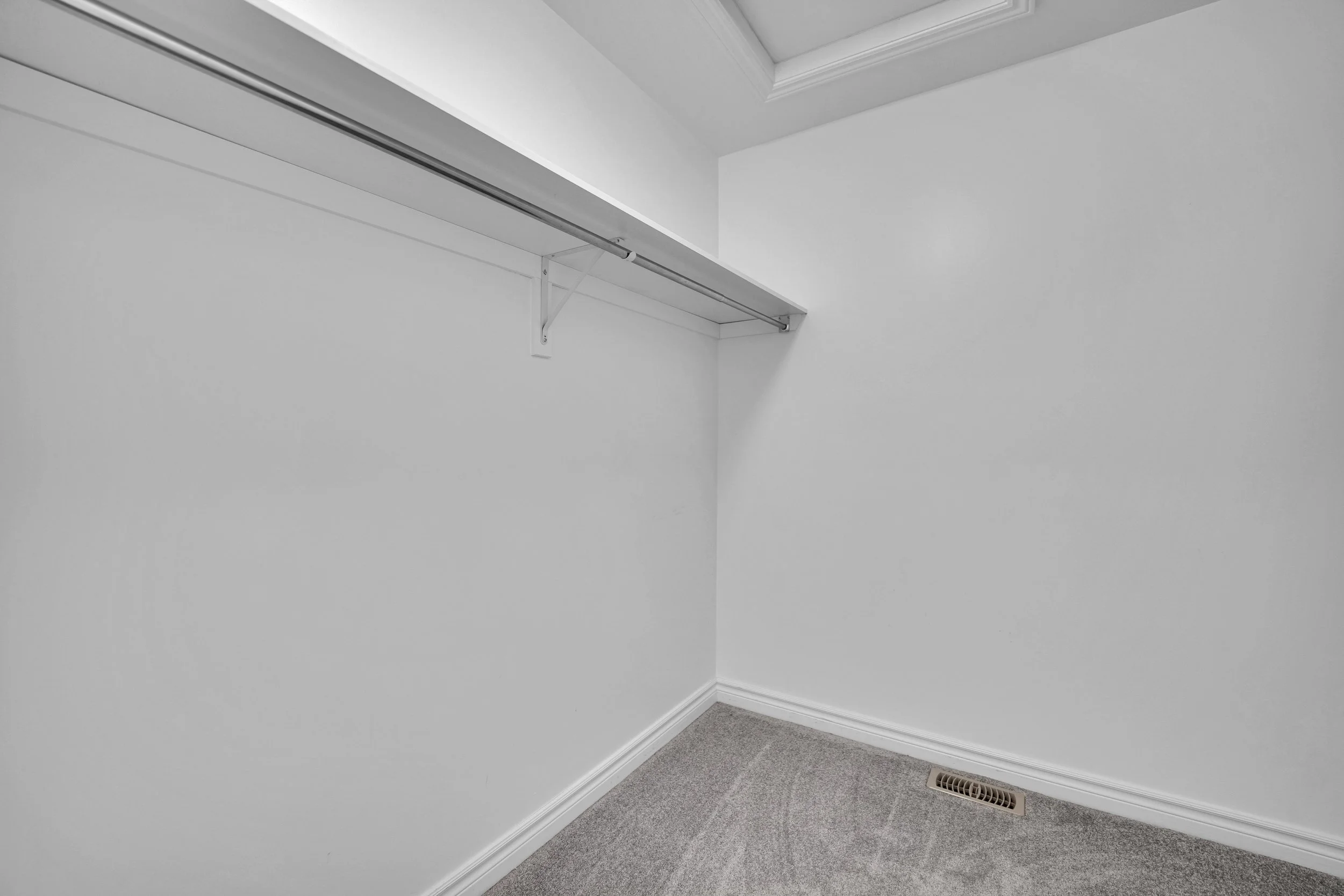 NVISION3D Real Estate Photography Ottawa  Empty corner of a room with white walls, a gray carpet, and a ceiling vent.