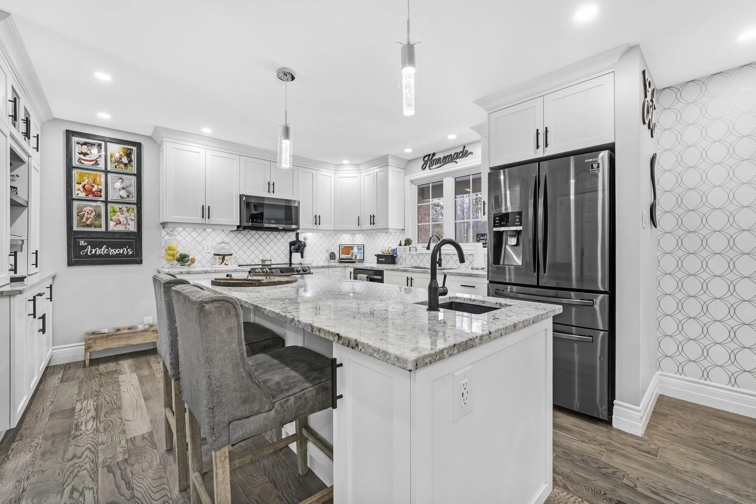 Ottawa Real Estate Photography  Modern kitchen with white cabinets, granite countertops, stainless steel appliances, and hardwood floors.