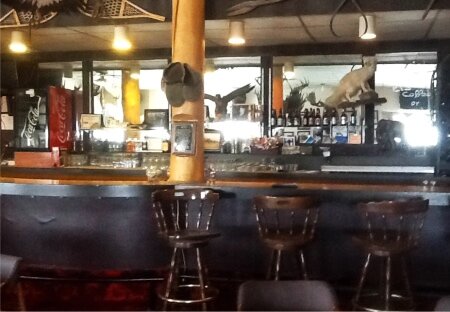 Eagle Plains Hotel, interior, dark wood bar,  bar stools, mirror behind bar