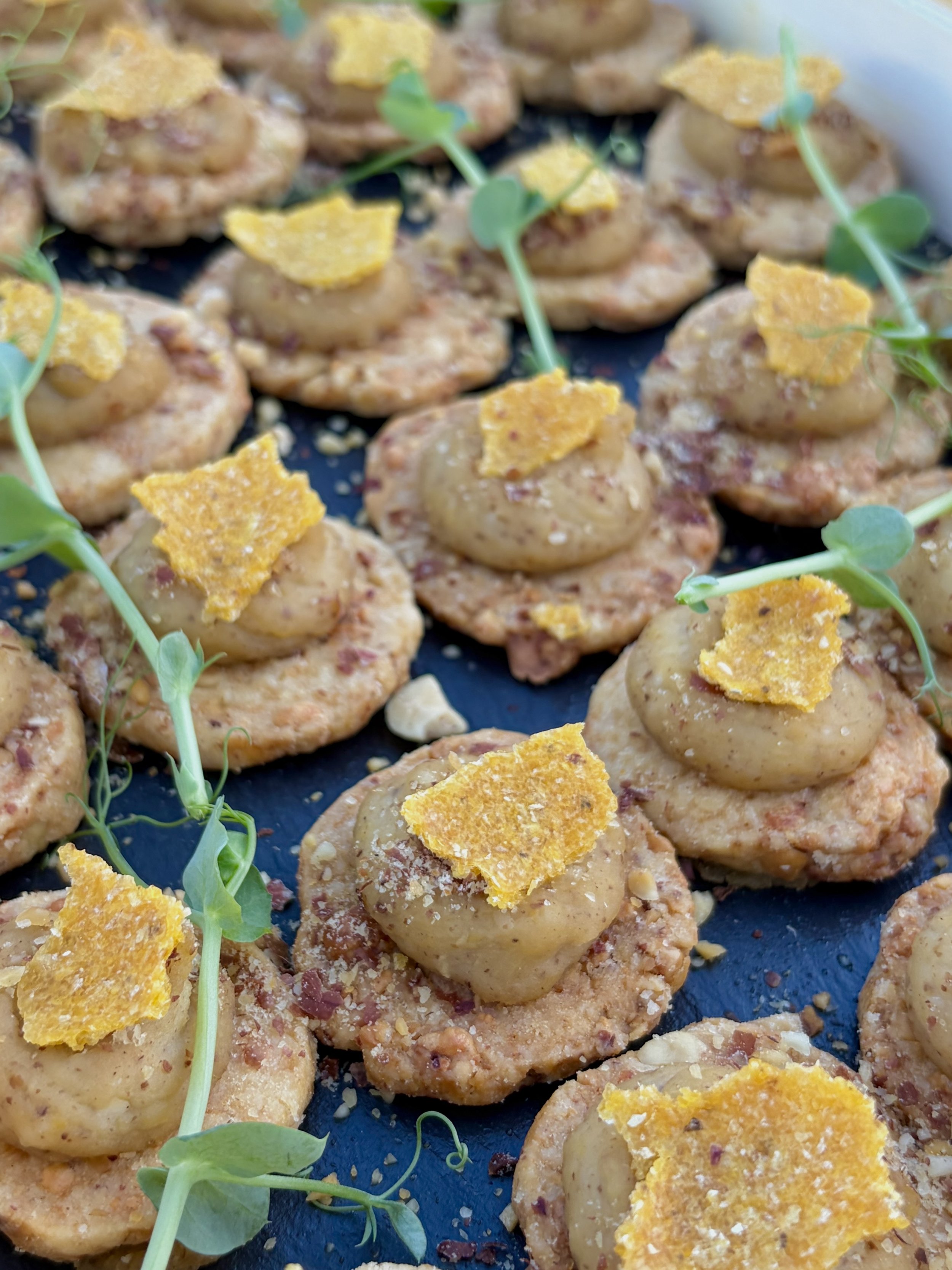 Généreux biscuits ou petits gâteaux garnis de morceaux de noix, de petits morceaux de caramel ou de chocolat, décorés de miettes et de micro-pousses vertes.