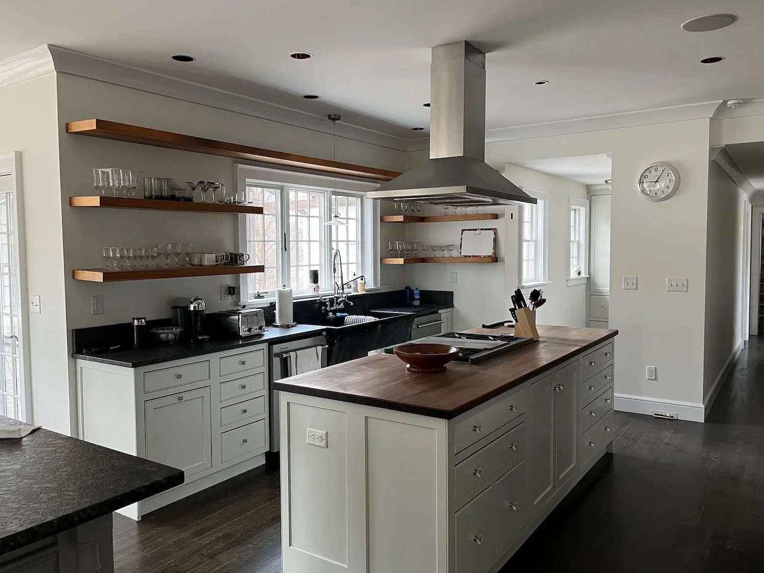 Open plan kitchen remodel with large island, soapstone countertops, floating walnut shelves, and island range hood — North Shore, MA