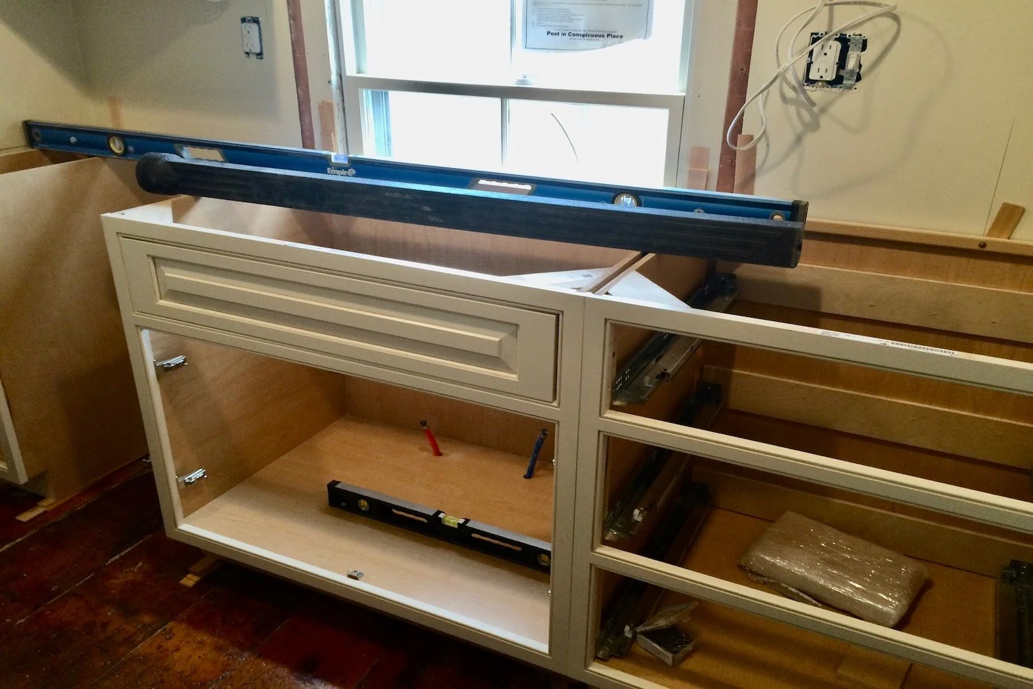 Kitchen cabinet installation in progress in an older New England home with wide plank floors in Newburyport MA