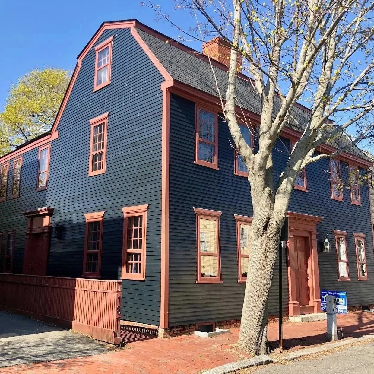 a blue antique house with red trim and door in newburyport