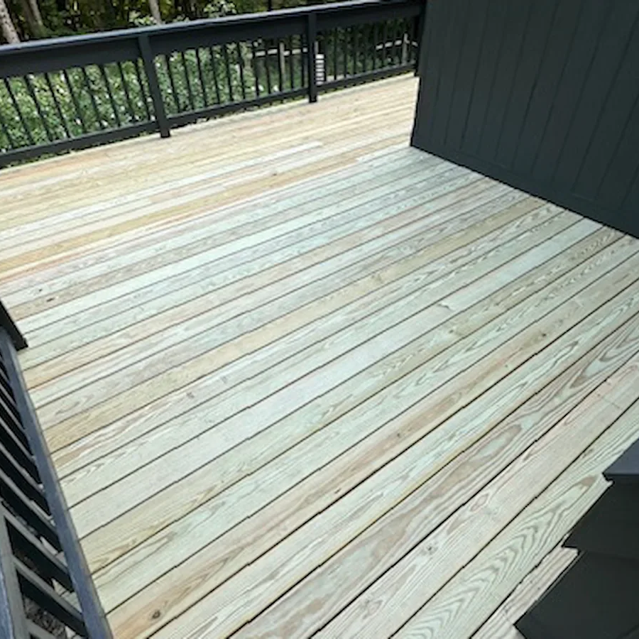 Newly completed pressure-treated deck with black metal railing, North Shore Massachusetts