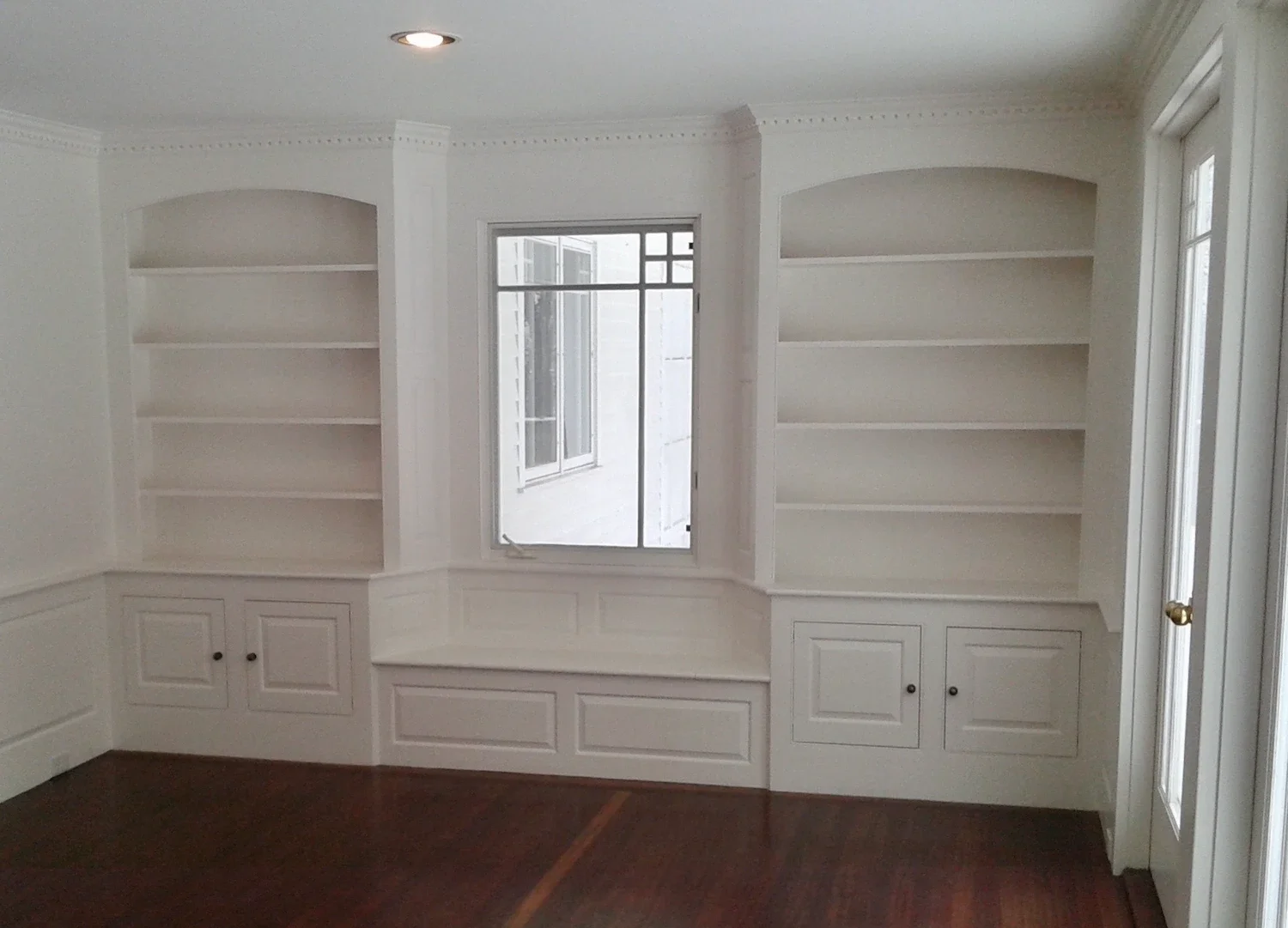 Interior painting with custom built-in bookshelves, window seat, crown molding, and white trim — Newburyport, MA