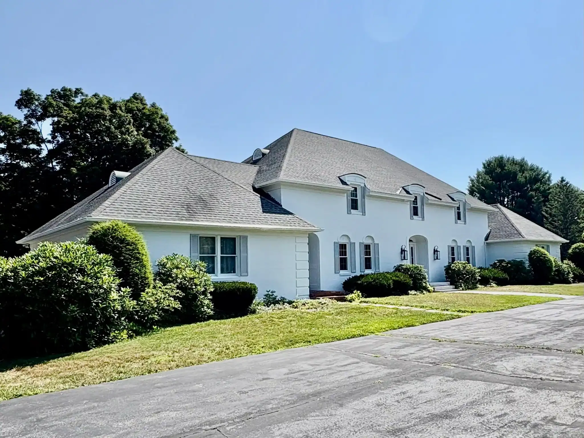 Exterior painting in Hampton NH — white Federal colonial with black doors by Albion Contracting