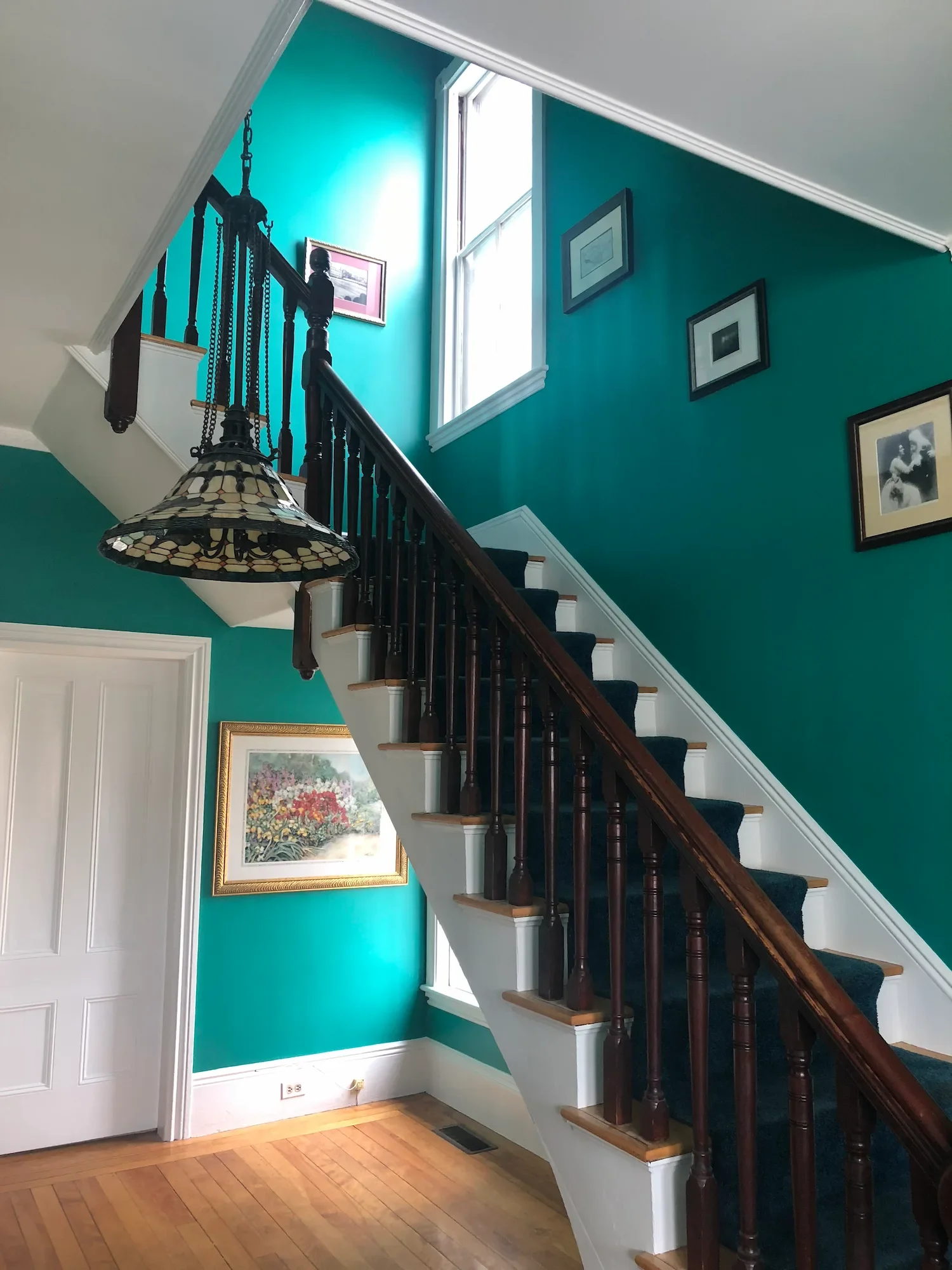 Interior painting featuring bold teal staircase walls, Victorian chandelier, and painted white trim — North Shore, MA