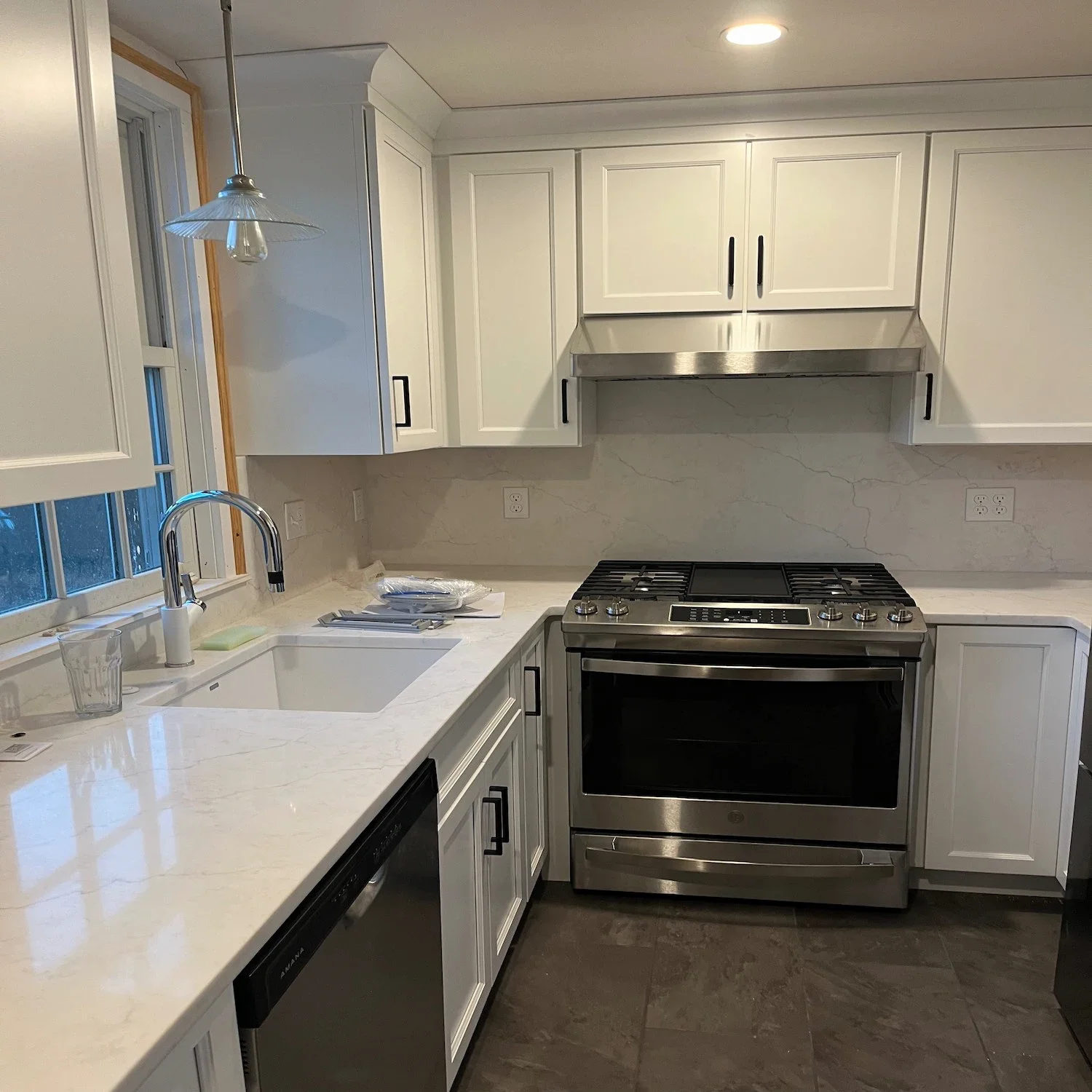 White shaker kitchen remodel with quartz countertops, gas range, marble slab backsplash, and stainless steel appliances — Newburyport, MA