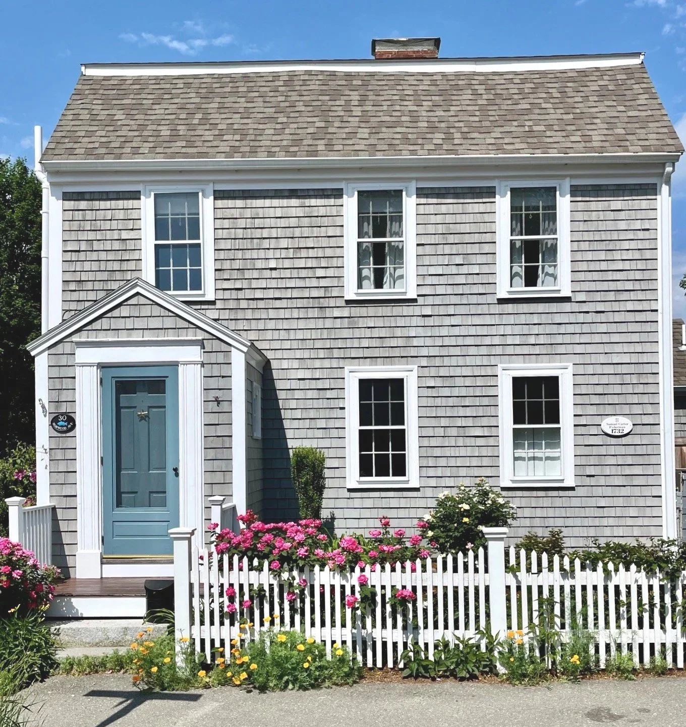Restored 1732 historic Cape style home with natural shingle siding and white trim in Newburyport MA