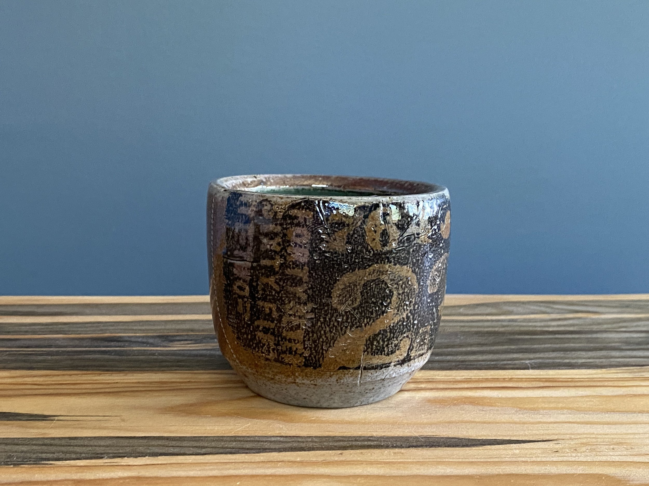 Stoneware cup with handmade monoprint transfers and stamped imagery