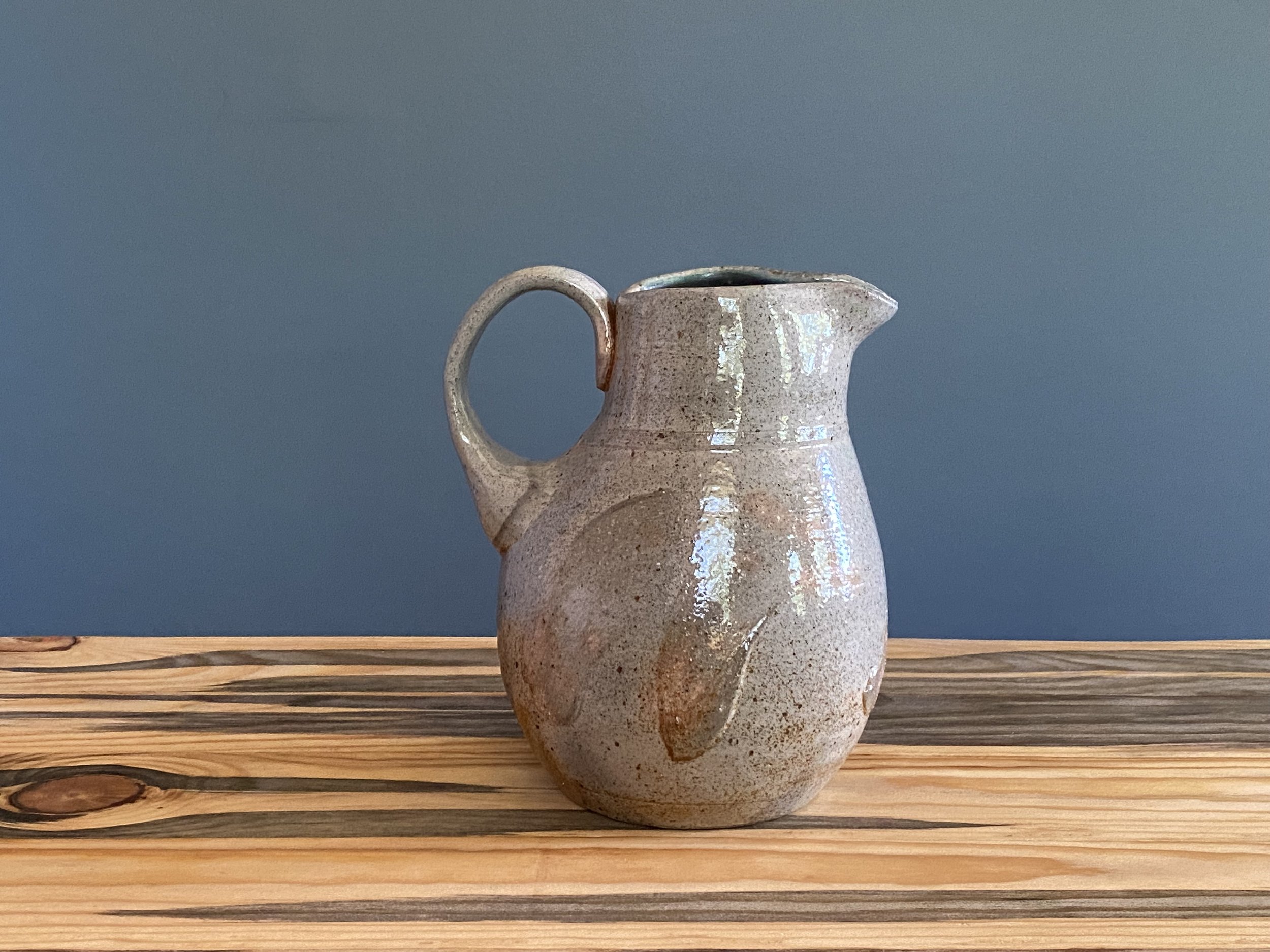 White stoneware pitcher with brushmarks of local clay slip