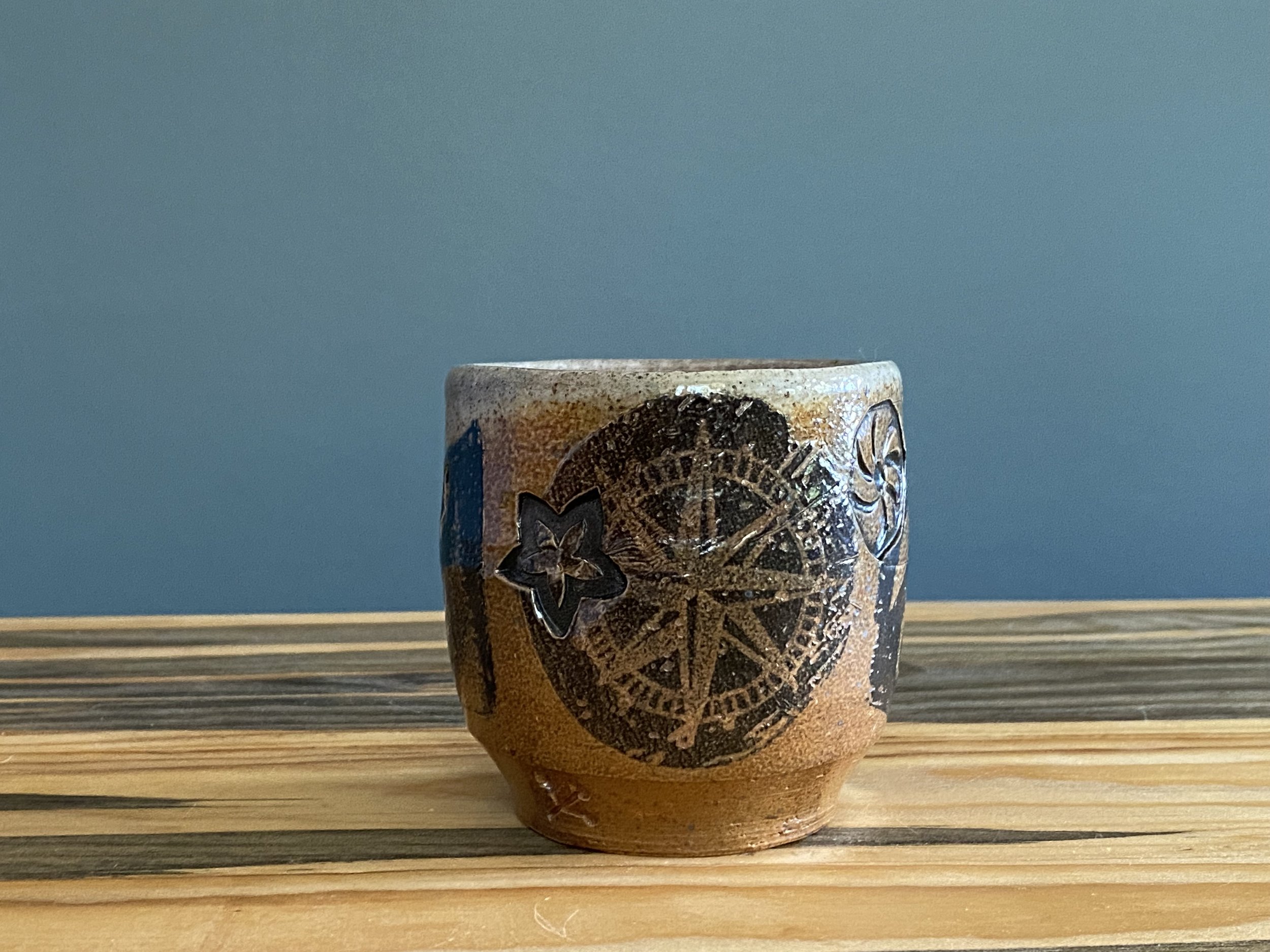 Stoneware cup with handmade monoprint transfers and stamped imagery