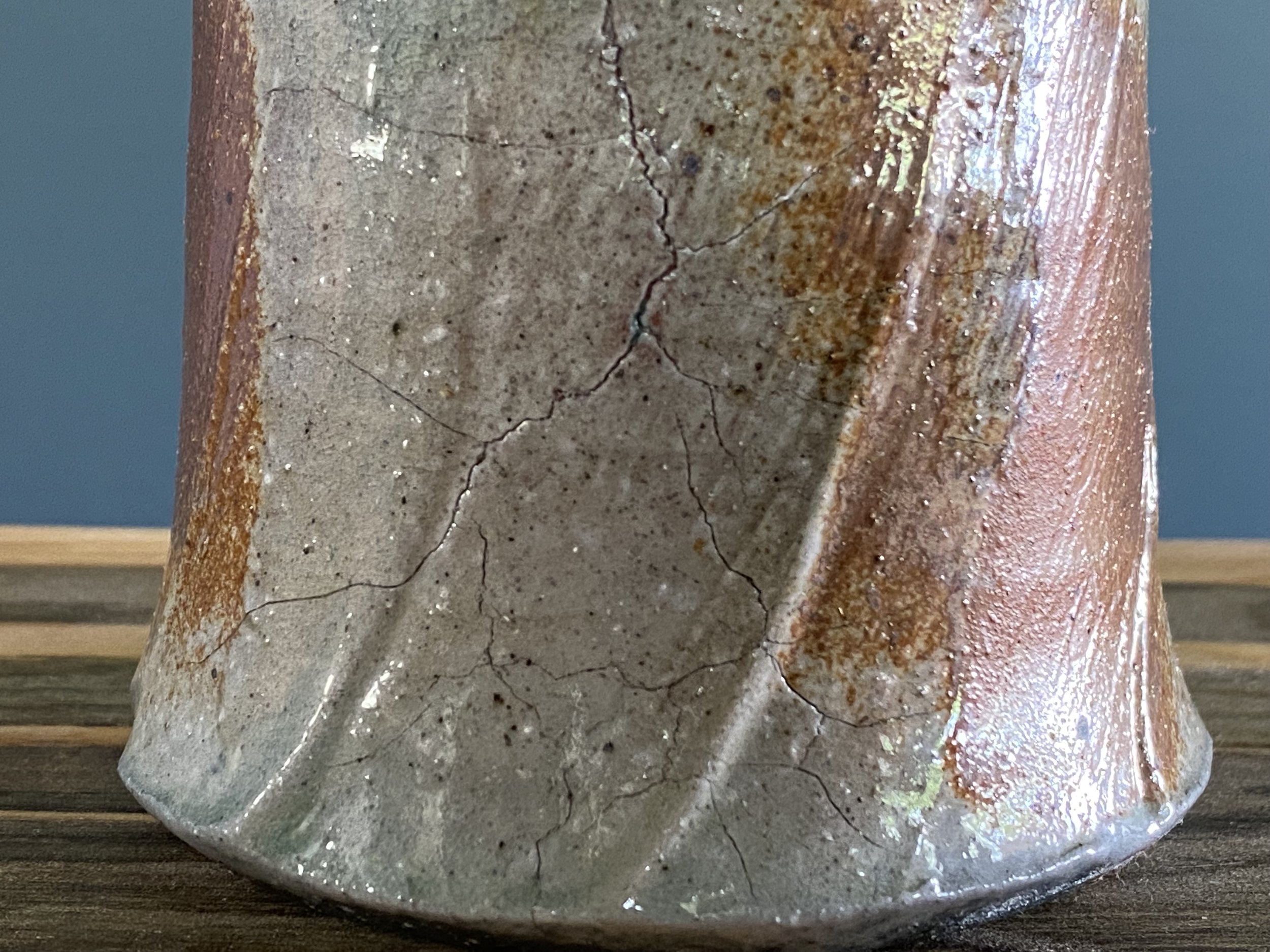Cup with significant fissure and seal with local clay slip brushed onto exterior