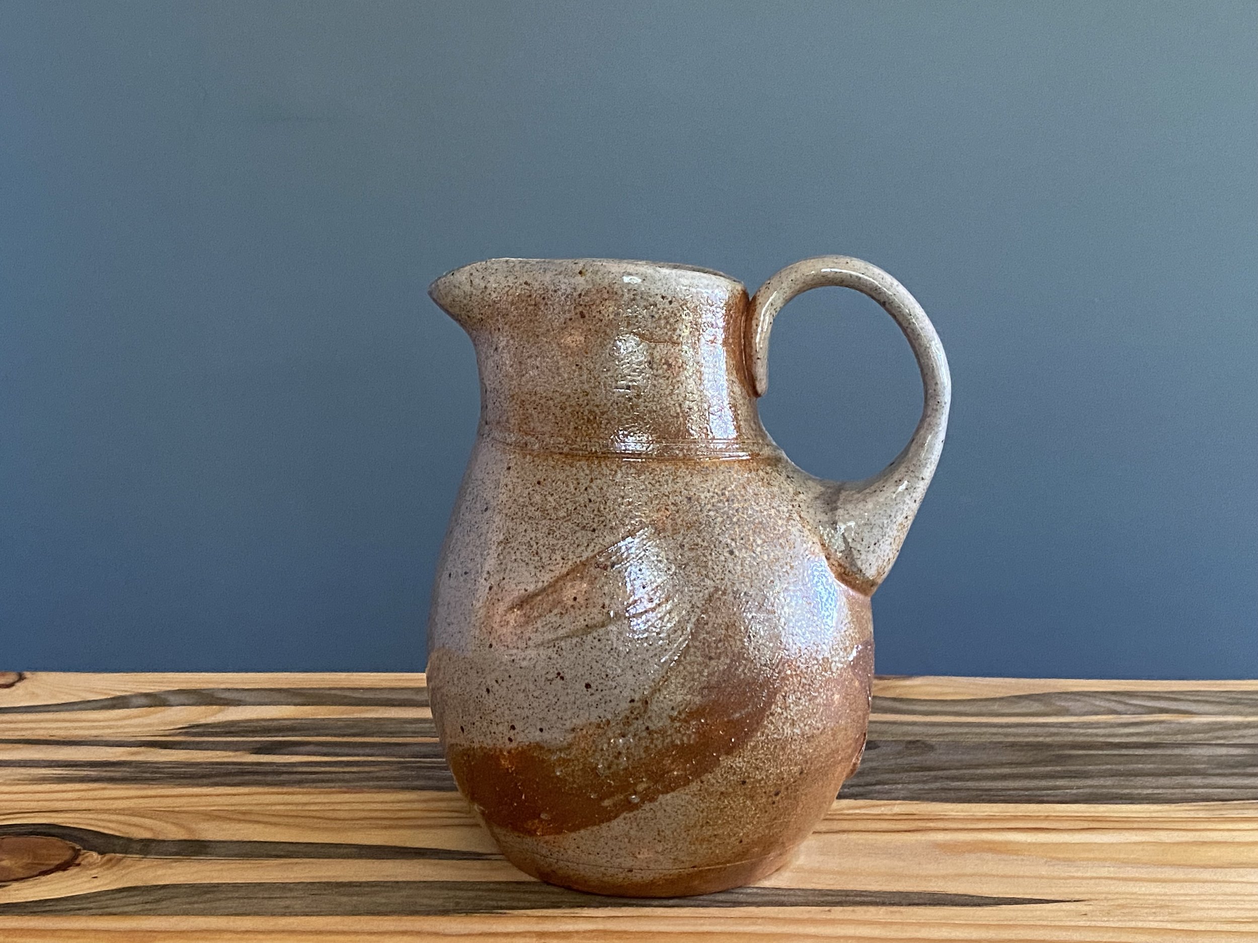 White stoneware pitcher with brushmarks of local clay slip
