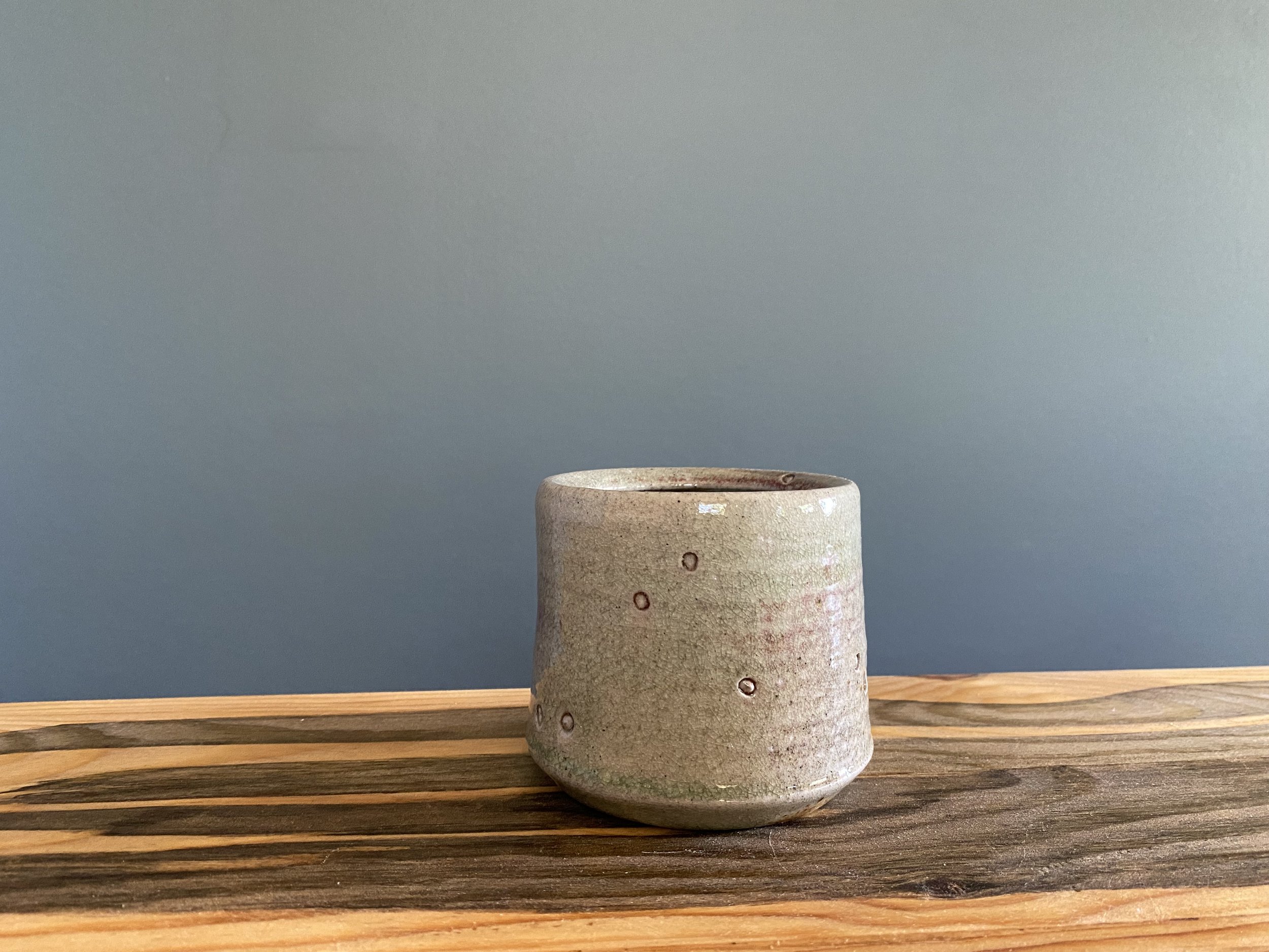 Stoneware cup with foraged material stamps and copper flashing