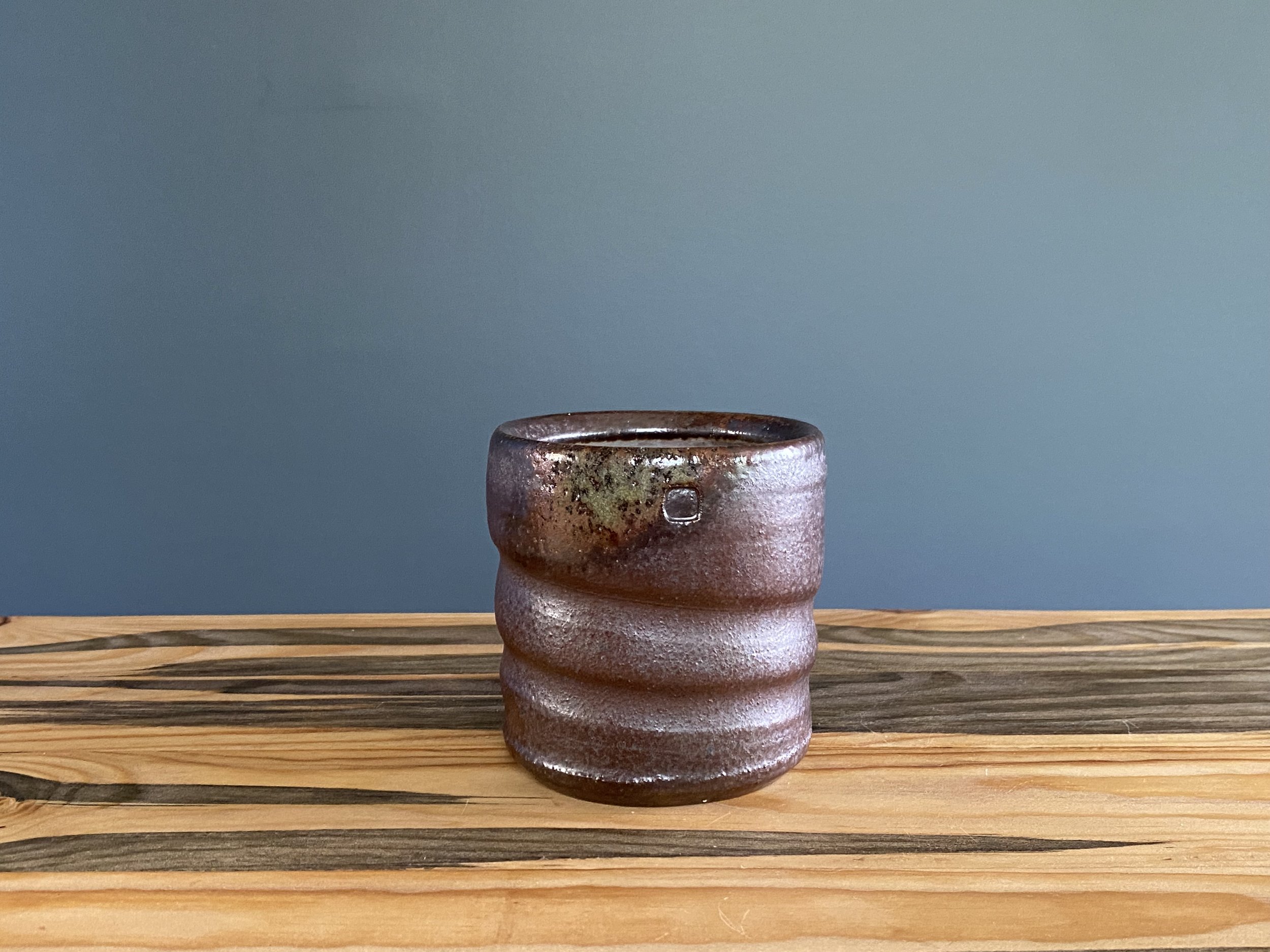 Dark stoneware cup with shino glaze