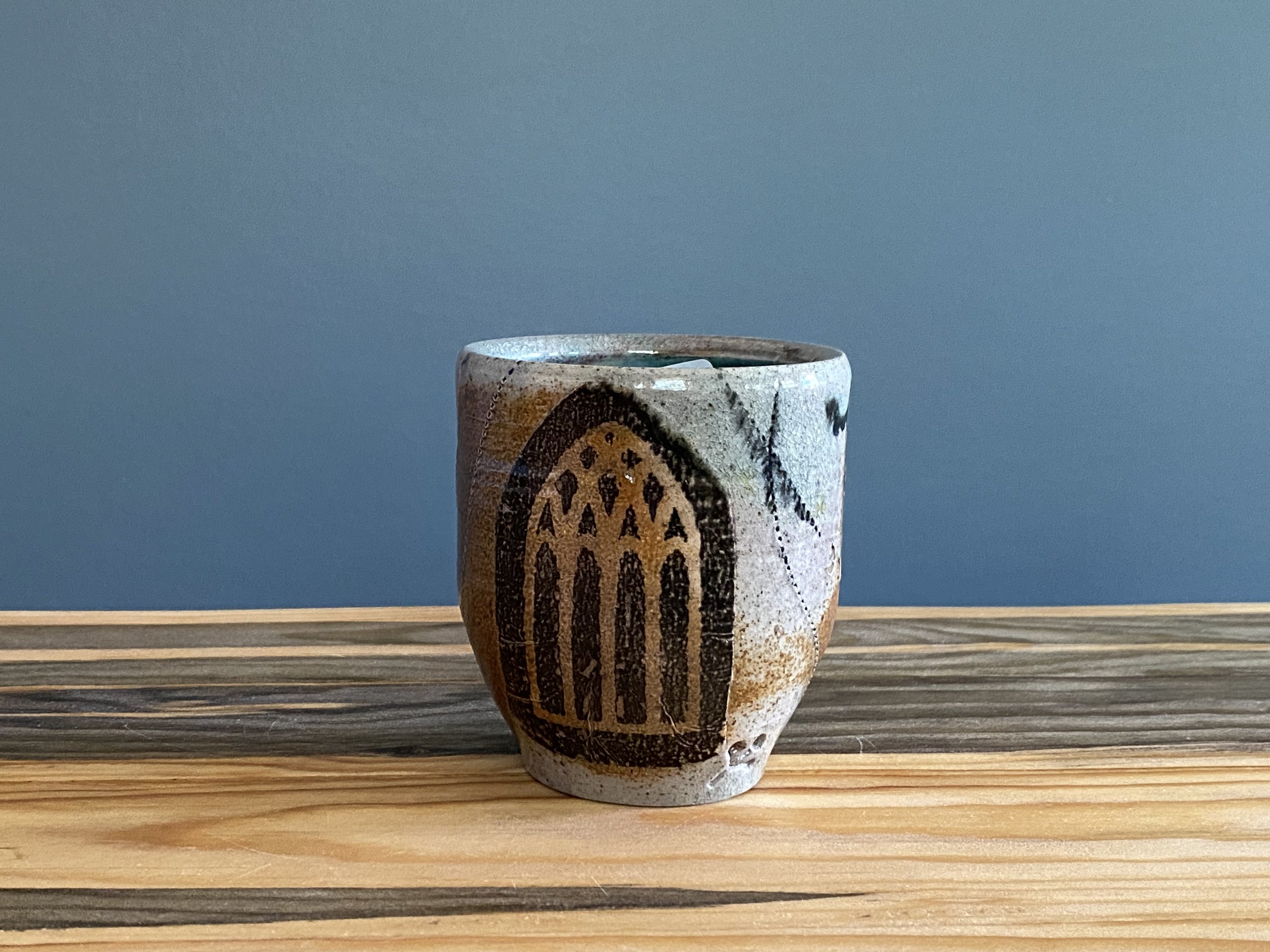 Stoneware cup with handmade monoprint transfers and stamped imagery