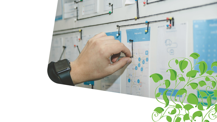 A hand pinning notes on a planning board – Competency Development Map