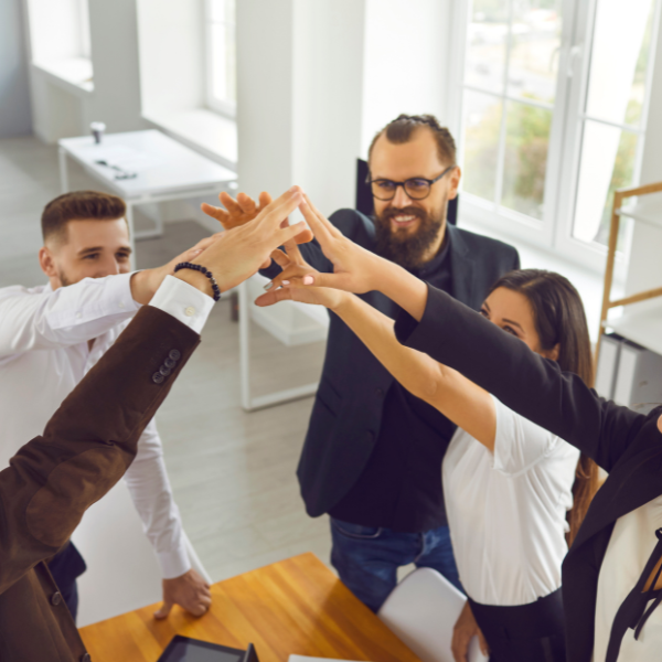 A team joining hands in the office – peer coaching and cooperation