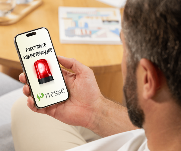 A manager holding a smartphone with the NESSE Competency First Aid chat