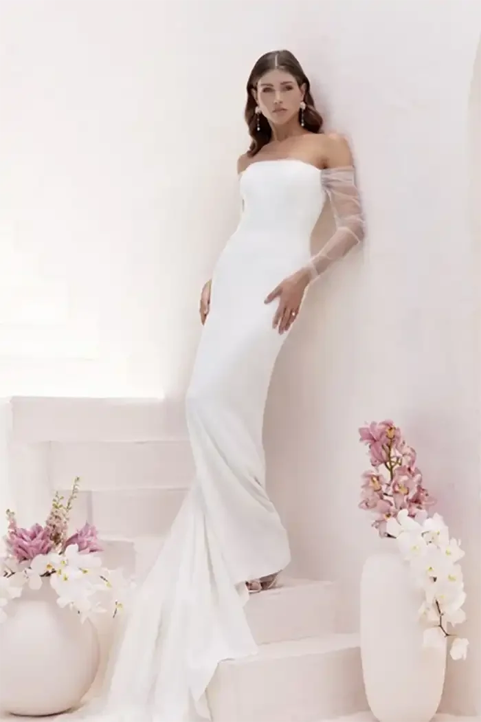 savvi-bridal-clean-strapless-organza-long-sleeve-fitted-on-model-wedding-dress-raleigh.webp