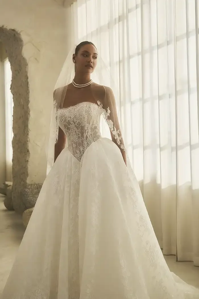 savvi-bridal-lace-strapless-basque-waist-ball-gown-on-model-raleigh.webp