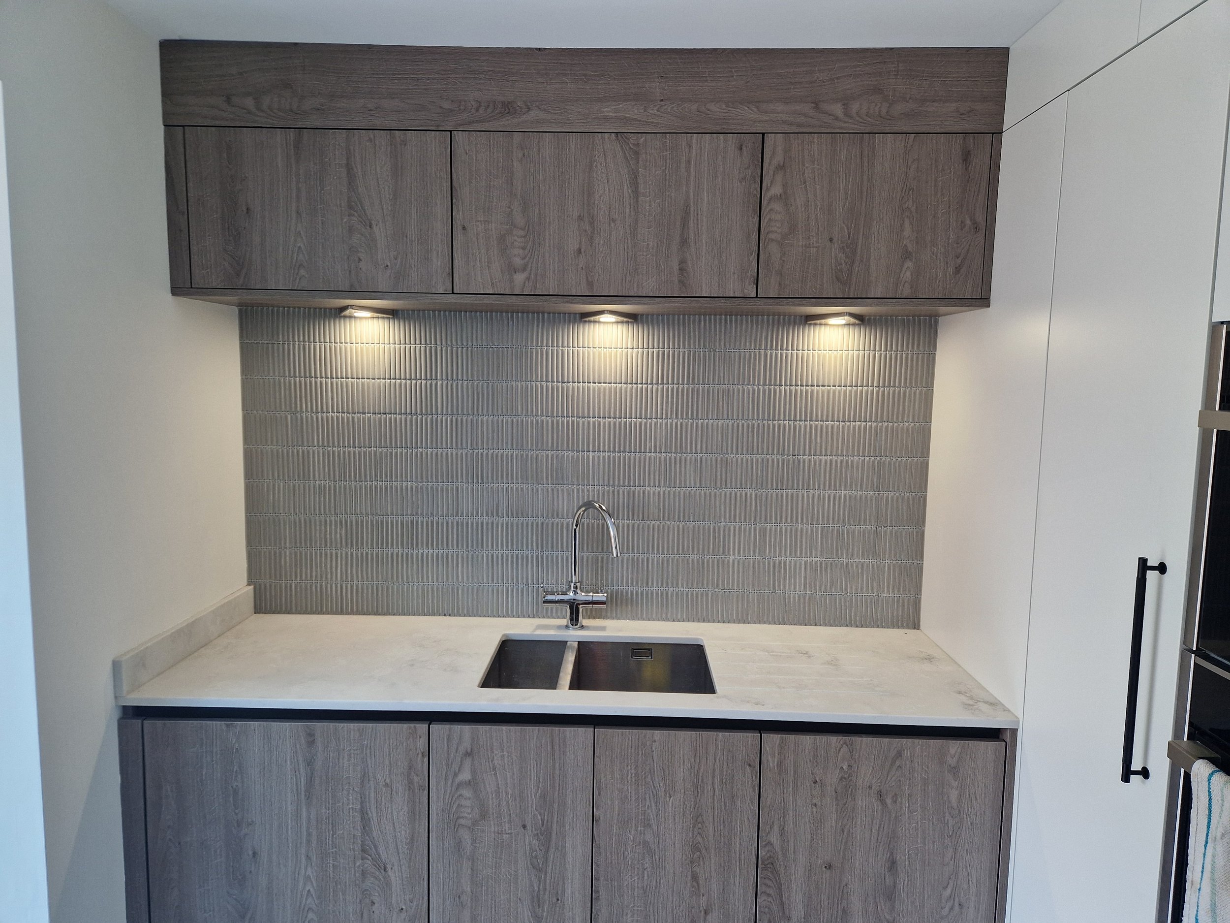 porcelain tall units matt black knurled handles true handleless handless matt anthracite truffle brown denver oak NEFF integrated coffee machine neff compact oven neff microwave CDA induction hob CDA downdraft extractor downlights stone affect floor