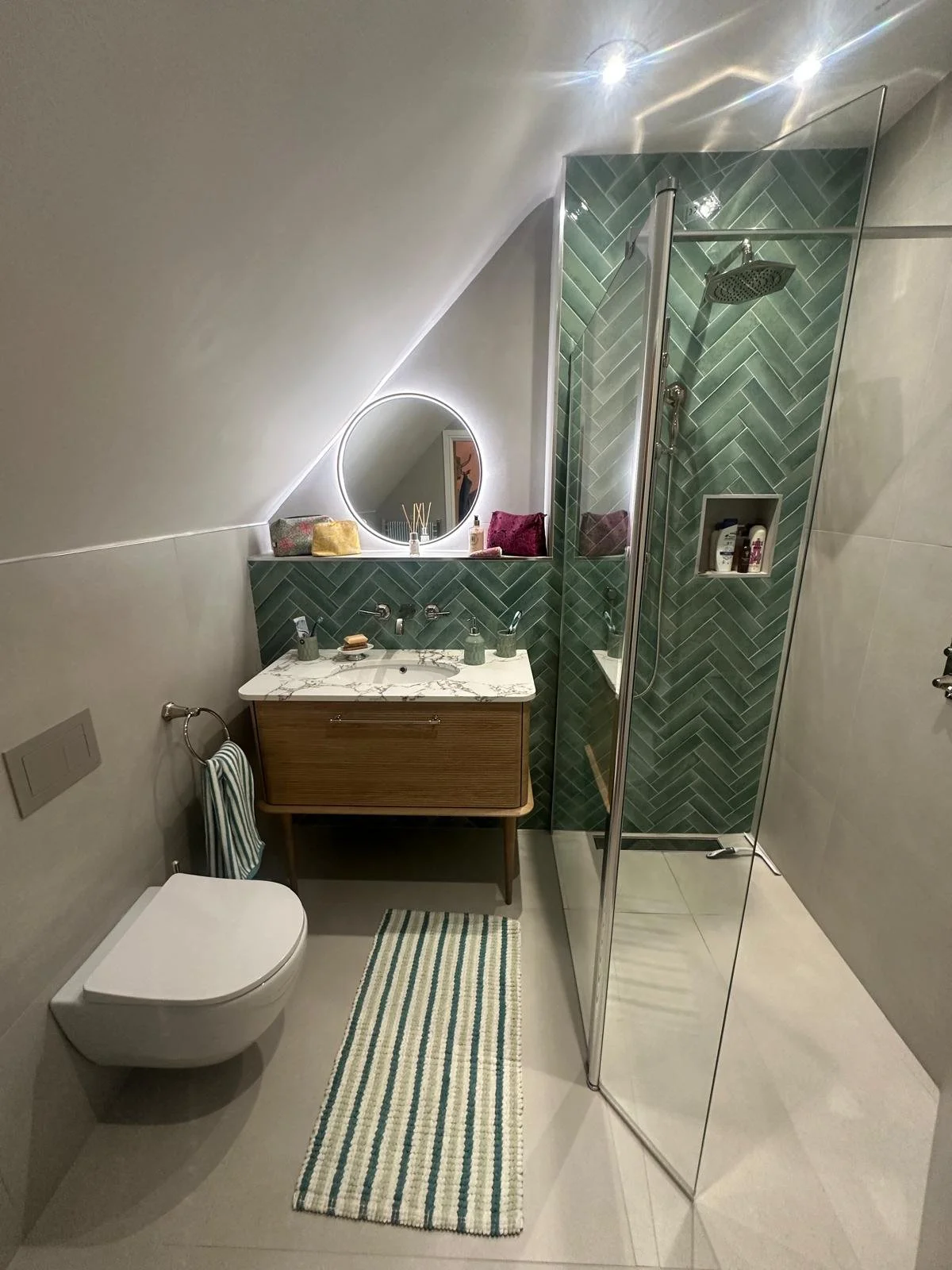 Bathrooms castle donington, bathrooms breedon, green bathroom tiles, lume tiles, turquoise tiles, feature tiles, round bathroom mirror, hib bathrooms, arbor mirror, light up mirror, smart mirror, wall hung toilet, oak vanity unit, inset sink, marble 