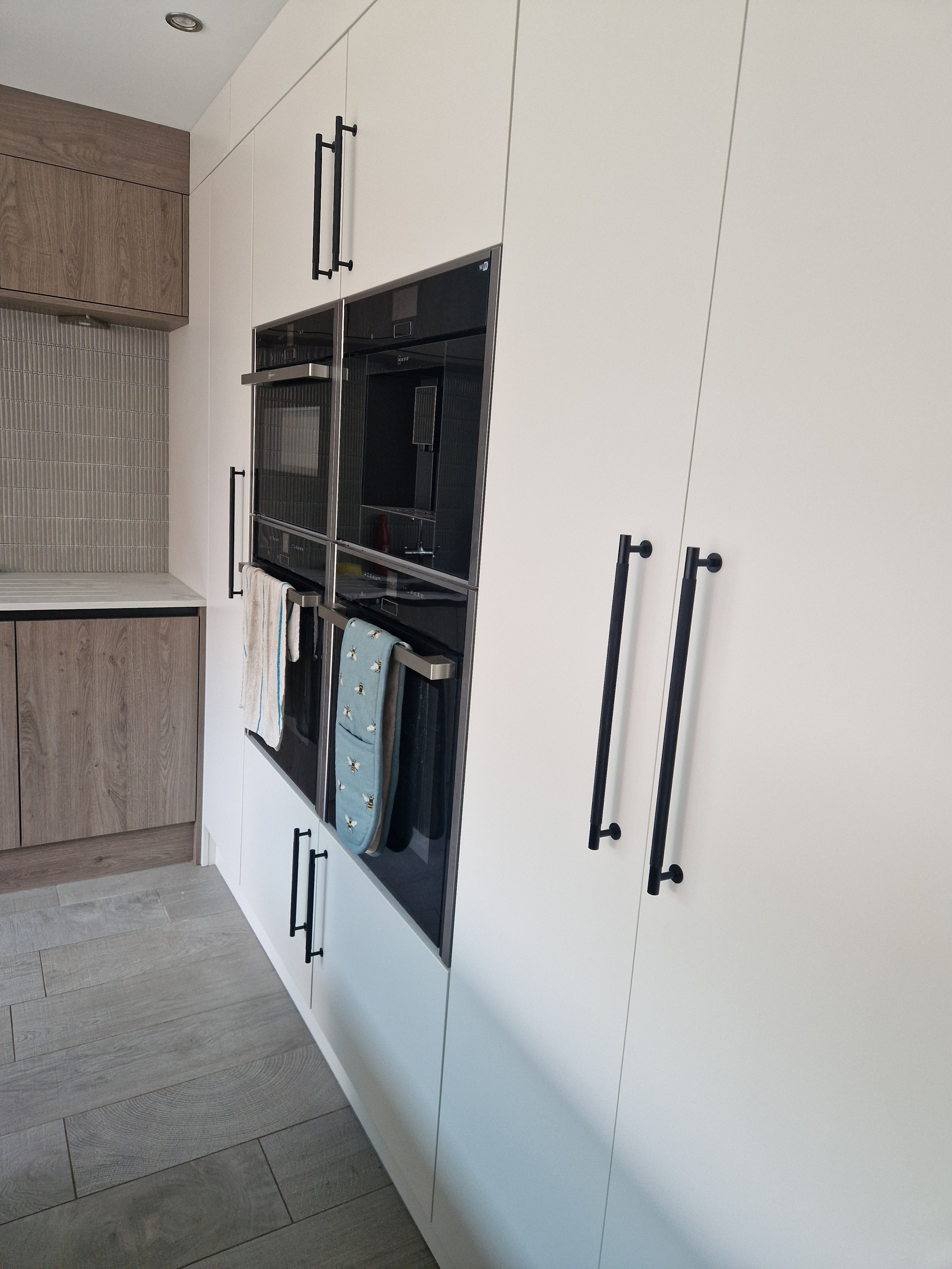 porcelain tall units matt black knurled handles true handleless handless matt anthracite truffle brown denver oak NEFF integrated coffee machine neff compact oven neff microwave CDA induction hob CDA downdraft extractor downlights stone affect floor