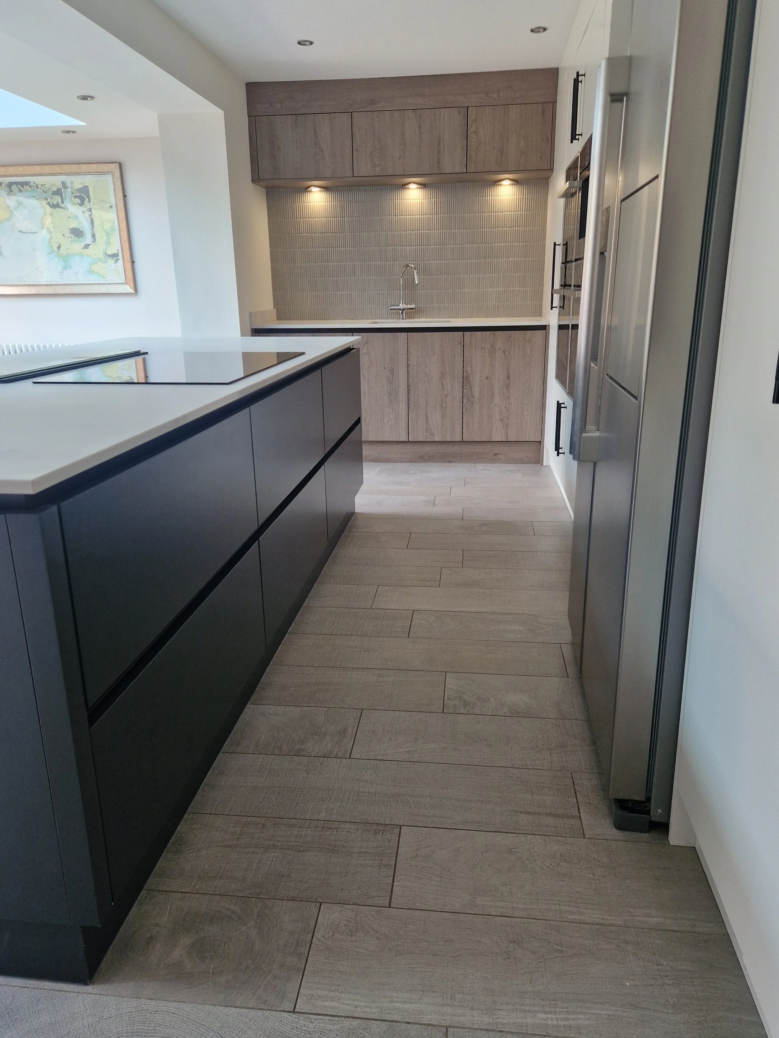 porcelain tall units matt black knurled handles true handleless handless matt anthracite truffle brown denver oak NEFF integrated coffee machine neff compact oven neff microwave CDA induction hob CDA downdraft extractor downlights stone affect floor