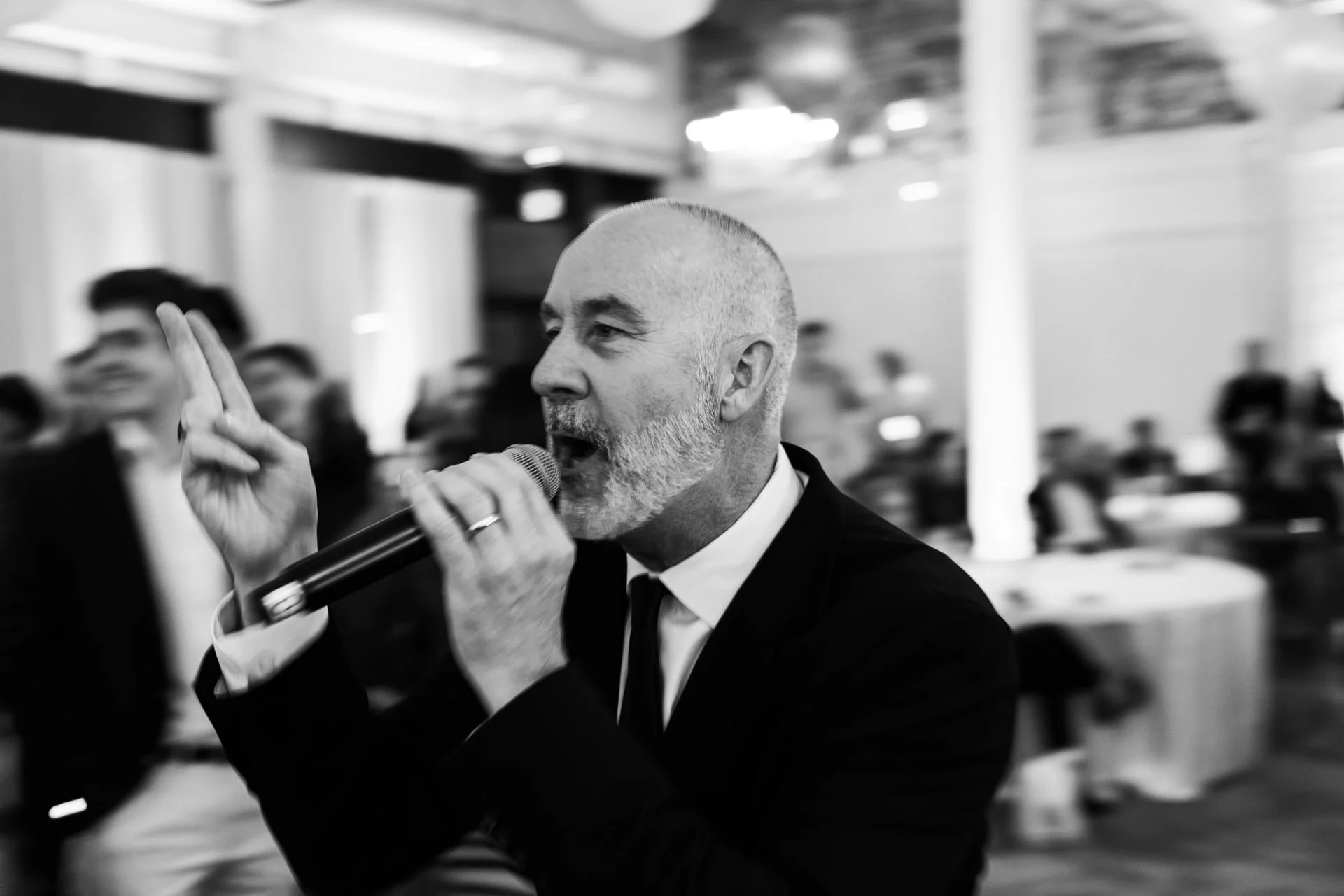 black and white photo of auctioneer at cookies for kids cancer event