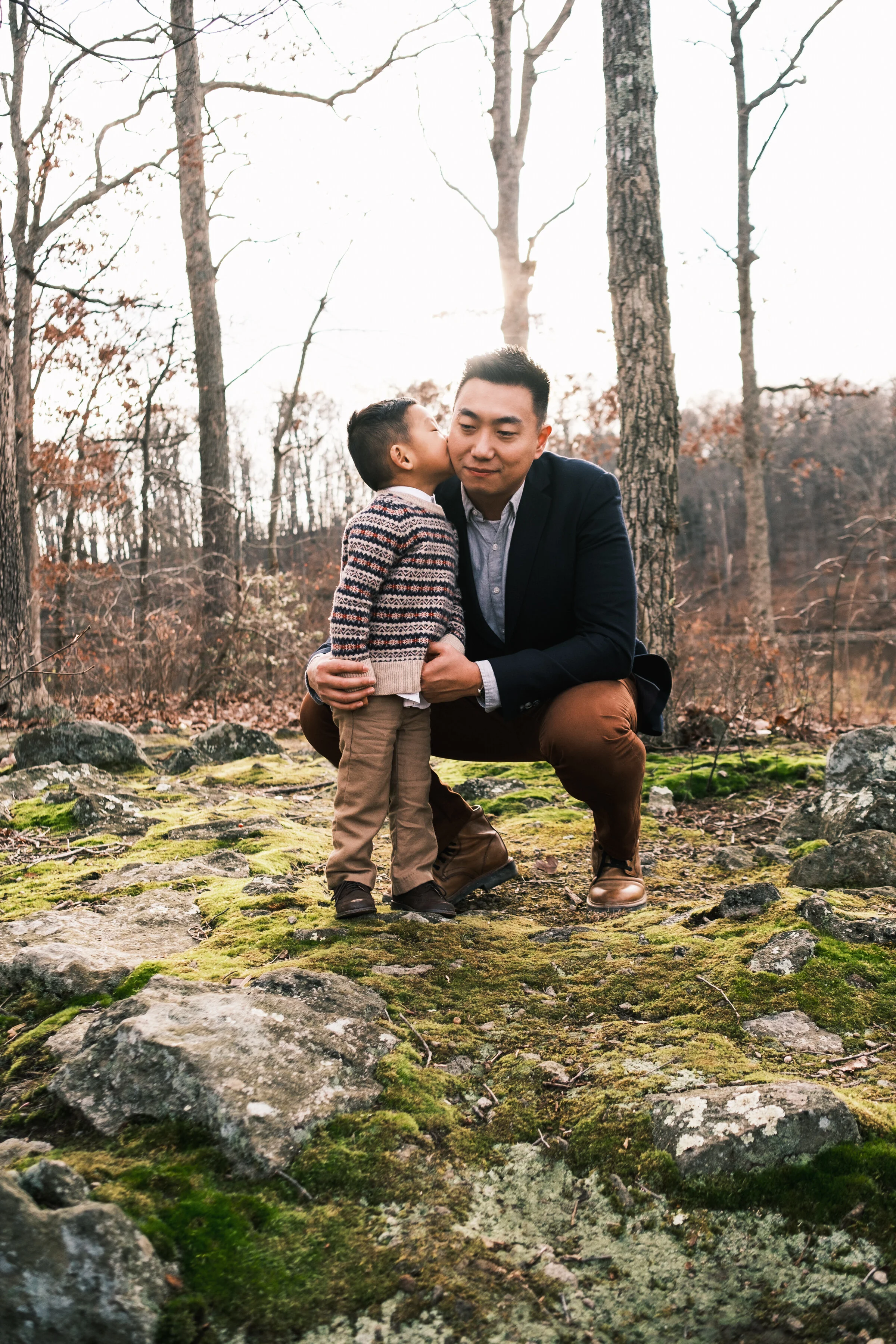 asian boy kissing his father on the cheek