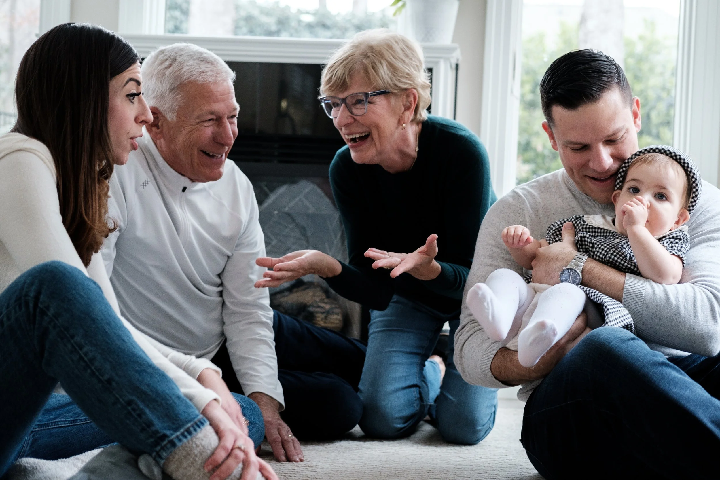 A family smiling and laughing in their living room during a family photo shoot from Brandon Pickett Photography in Charlotte, NC