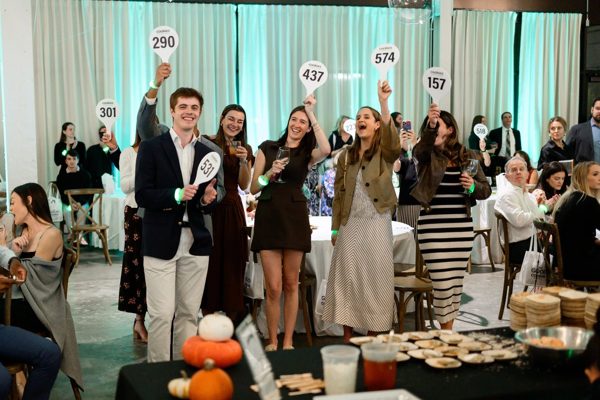 group of people holding up numbered paddles captured by Charlotte, NC photographer