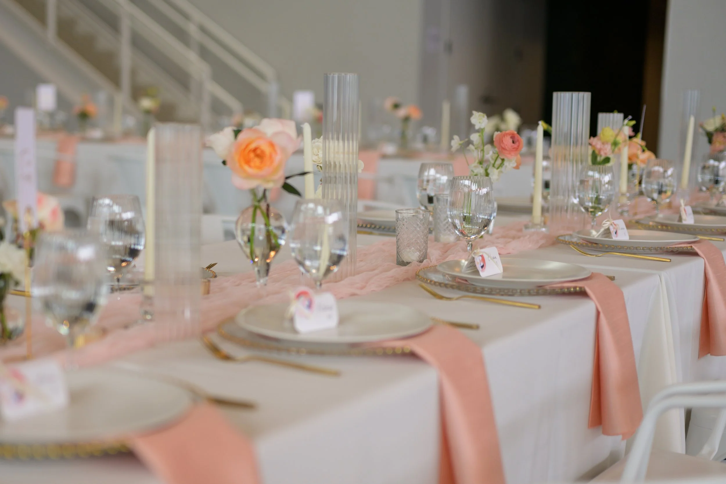 Wedding table with pink and white cloth with flowers and plates,forks at Pine wedding venue in Charlotte