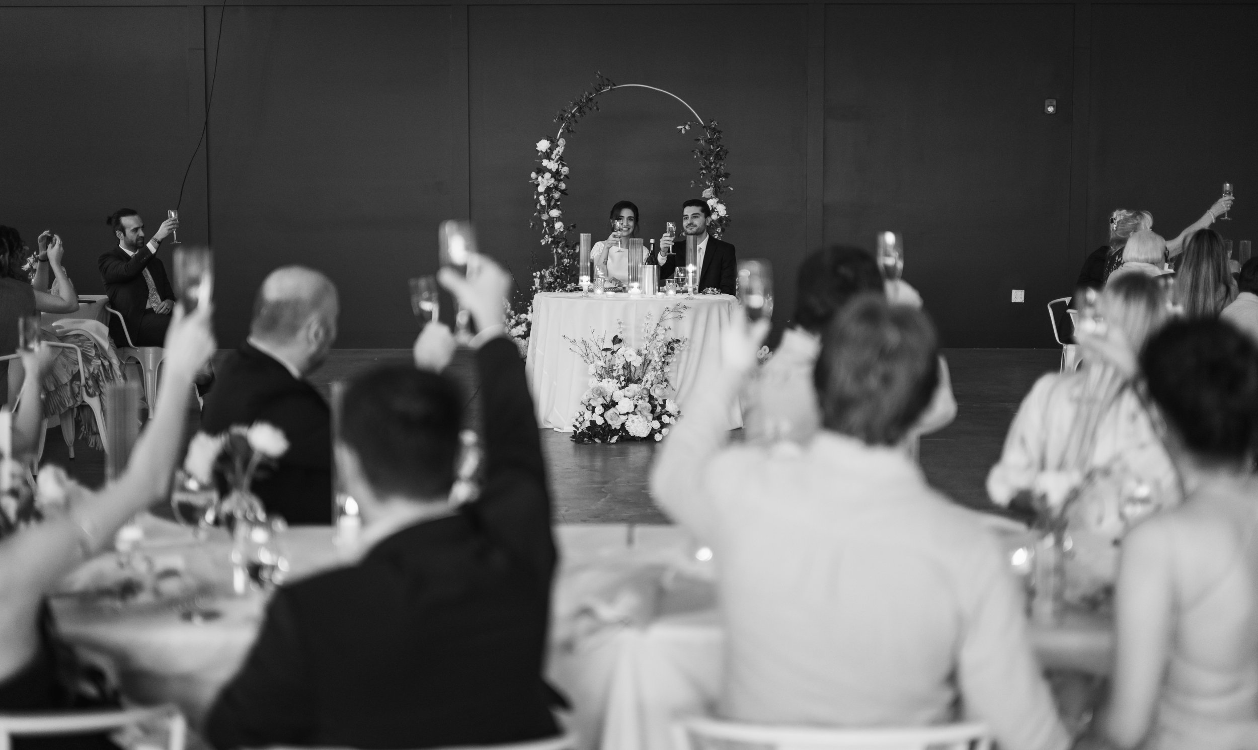 Engagement party dinner reception at PINE in NoDa, Charlotte NC. Guests are toasting to the bride and groom