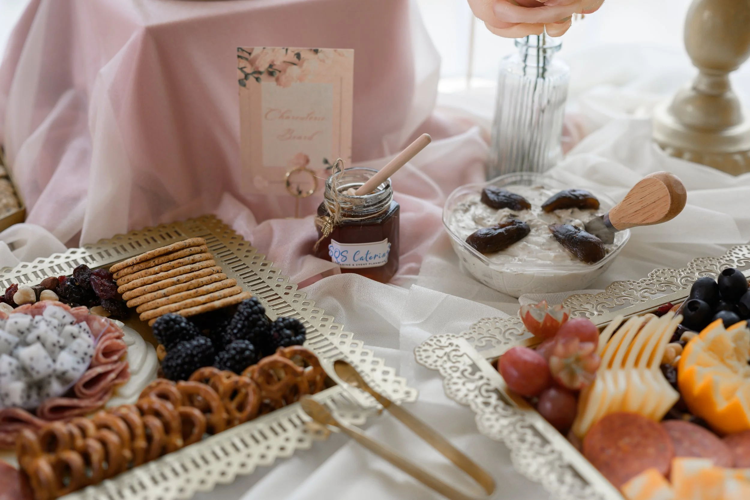 Food and dips on a table with pink cloth at a wedding reception in Charlotte
