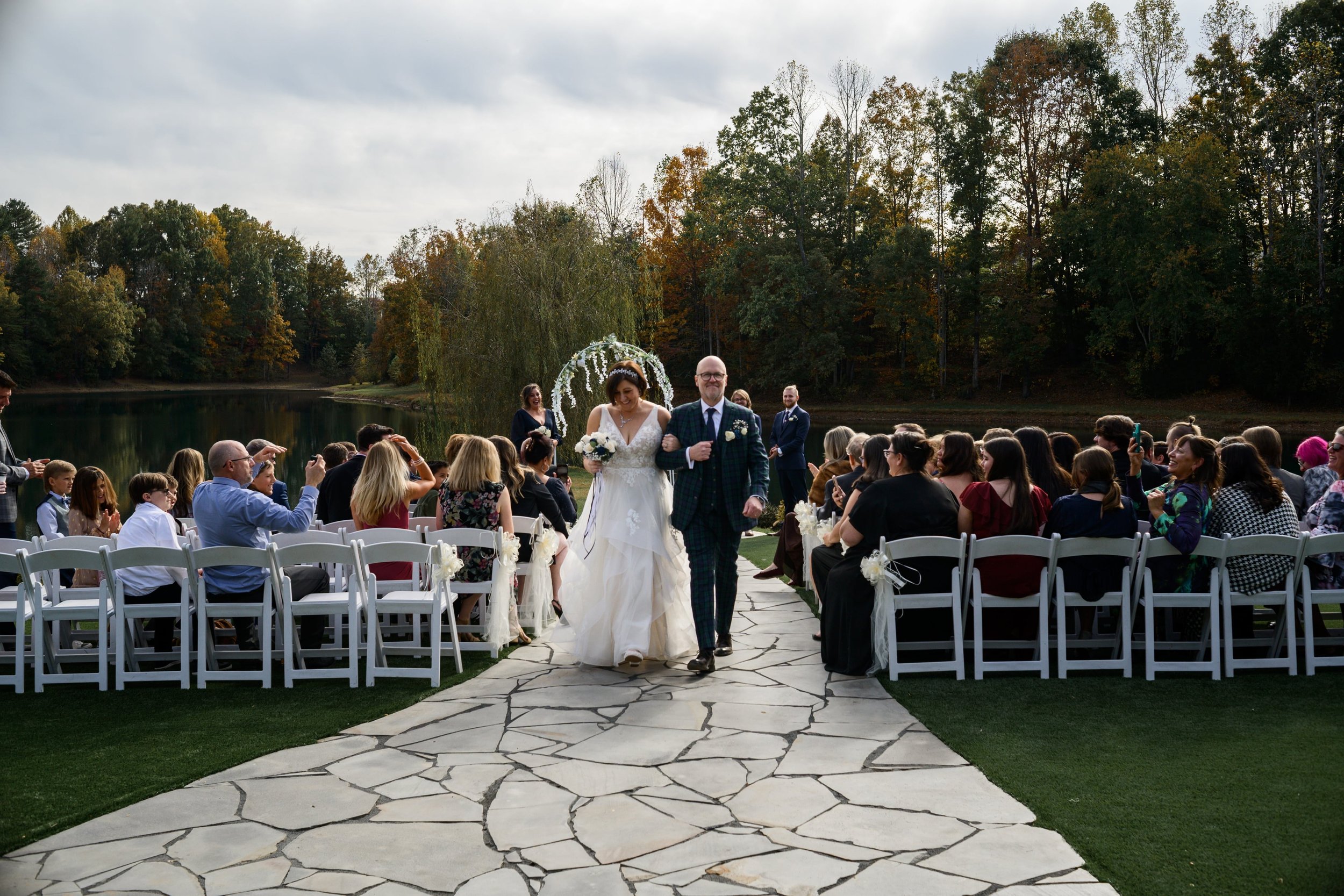bride and groom walking down isle at Splendor Pond Flower Farm after wedding ceremony