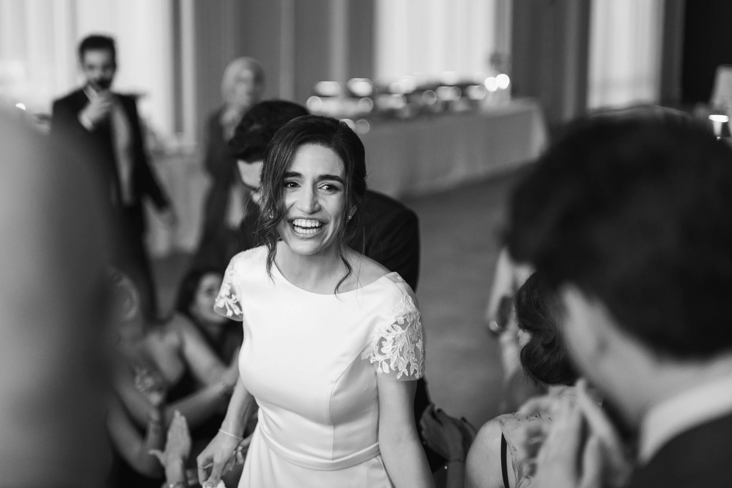 black and white photo of a bride wearing a white dress smiling during her wedding reception at Pine venue in NoDa Charlotte