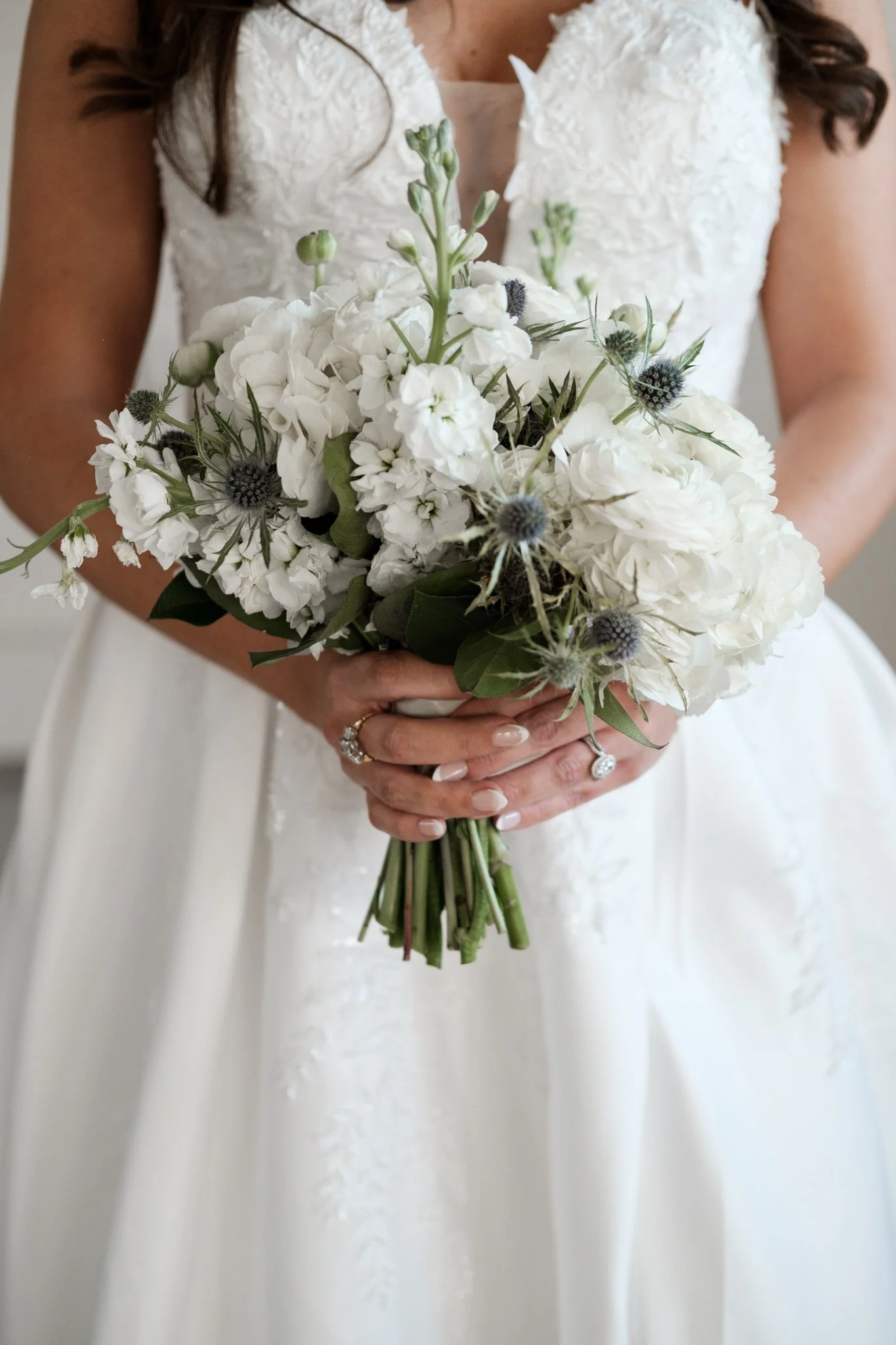bride in white wedding dress holding bouquet of flowers