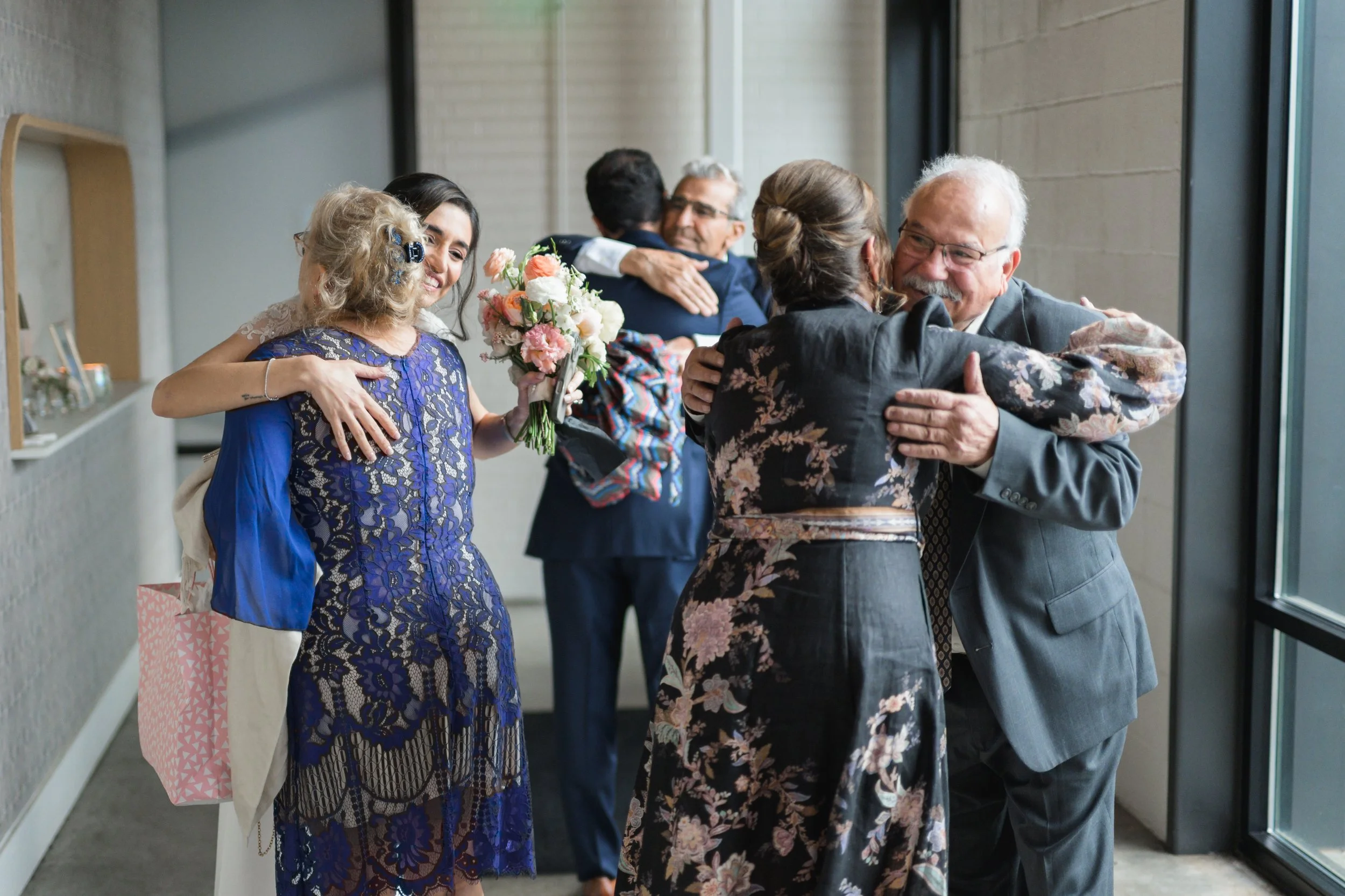 Three hugs happening at once during a wedding in NoDa, Charlotte