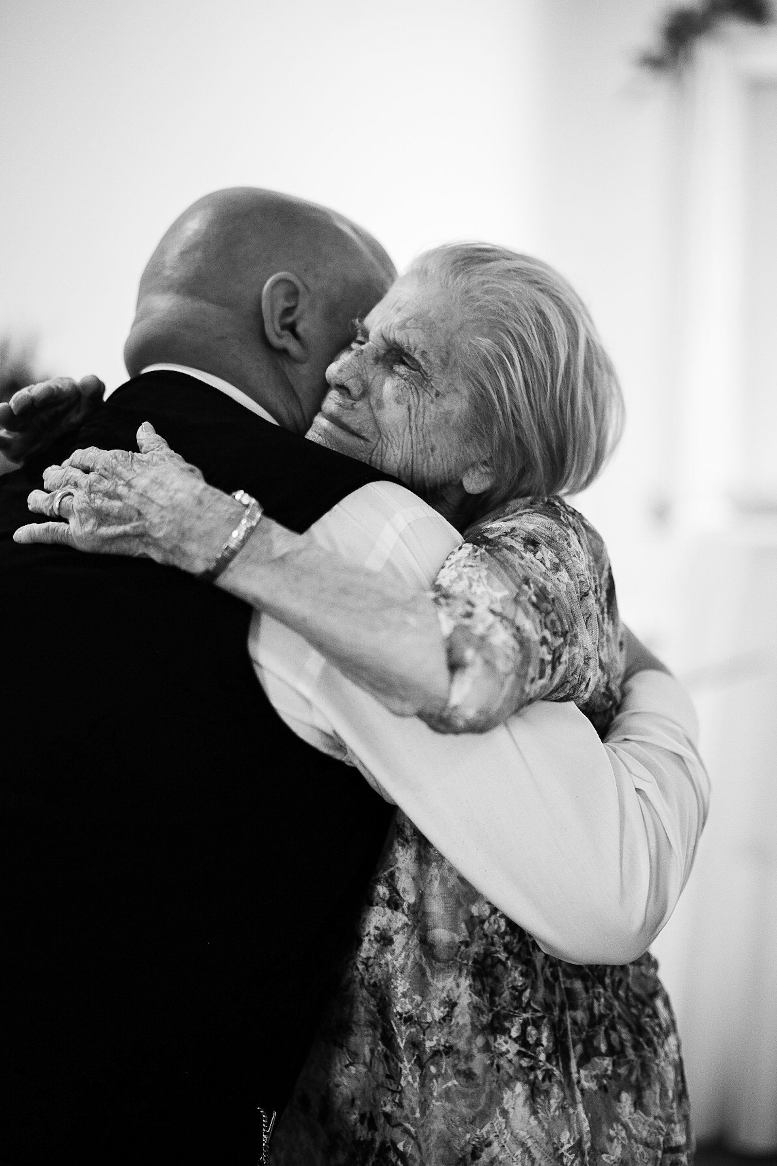 deeply emotional black and white photo of a grandmother hugging her grandson after he got married in Charlotte, NC