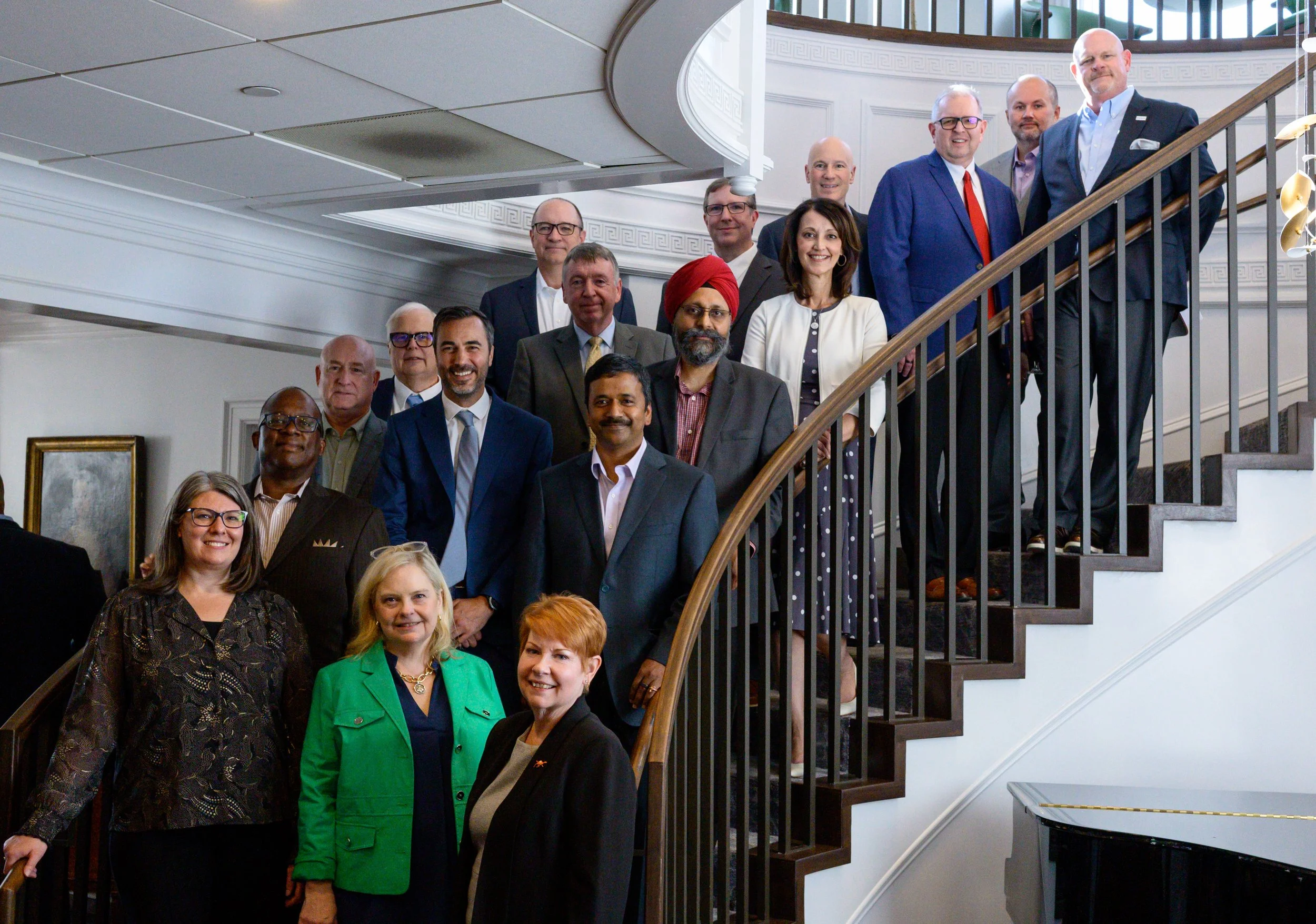 Group of professional men and women posing on a staircase in a formal setting by brandon pickett photography