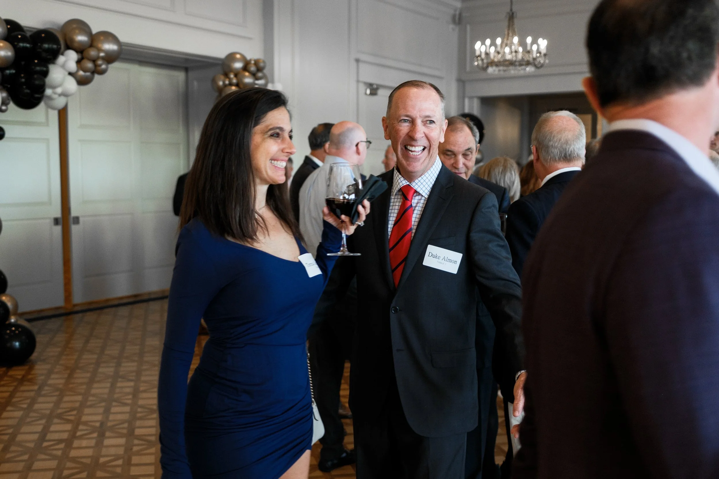 Man wearing a suit laughing during his retirement party at Myers Park Country Club in Charlotte