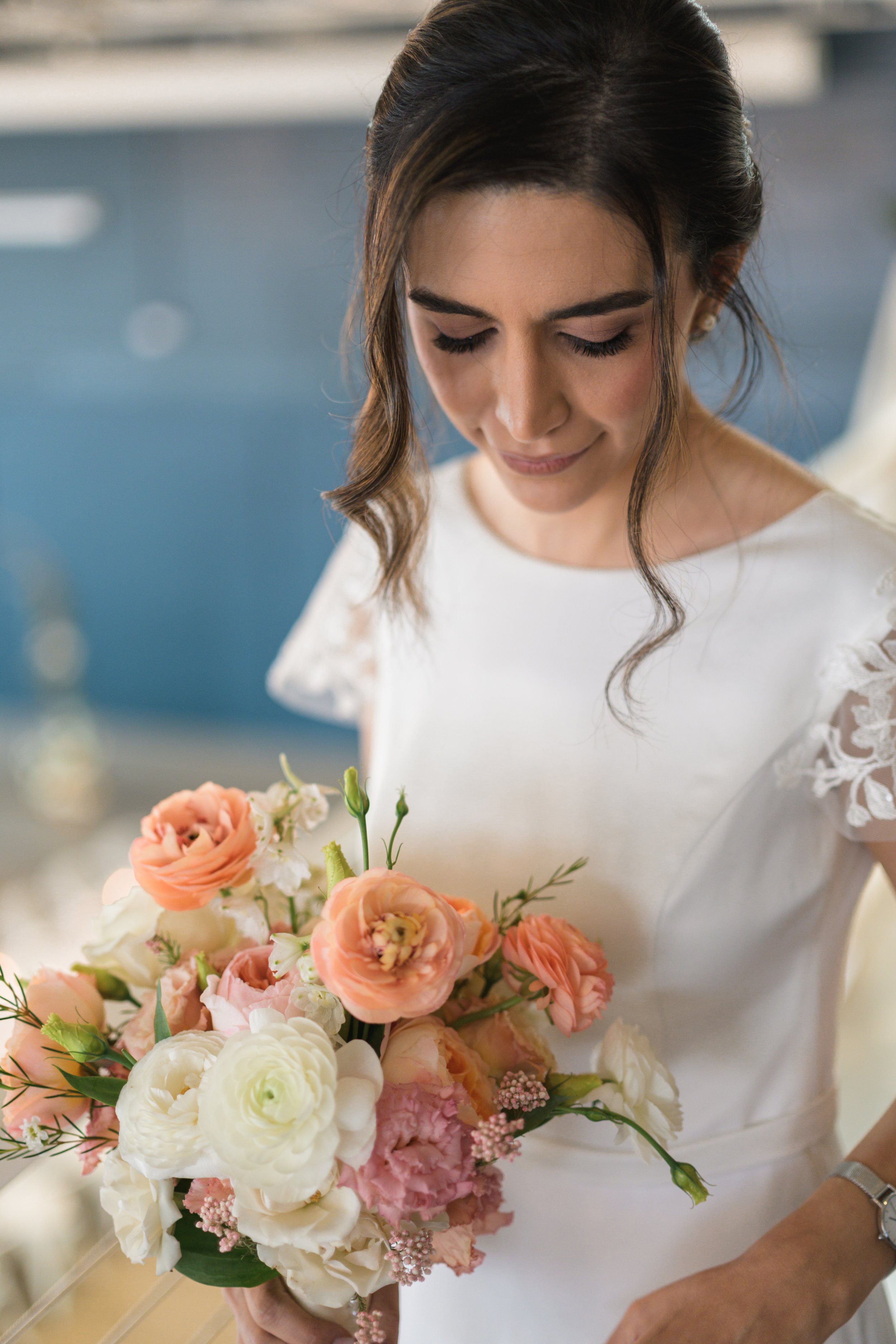 bride looking down at her bouquet of flowers at Pine wedding venue in charlotte