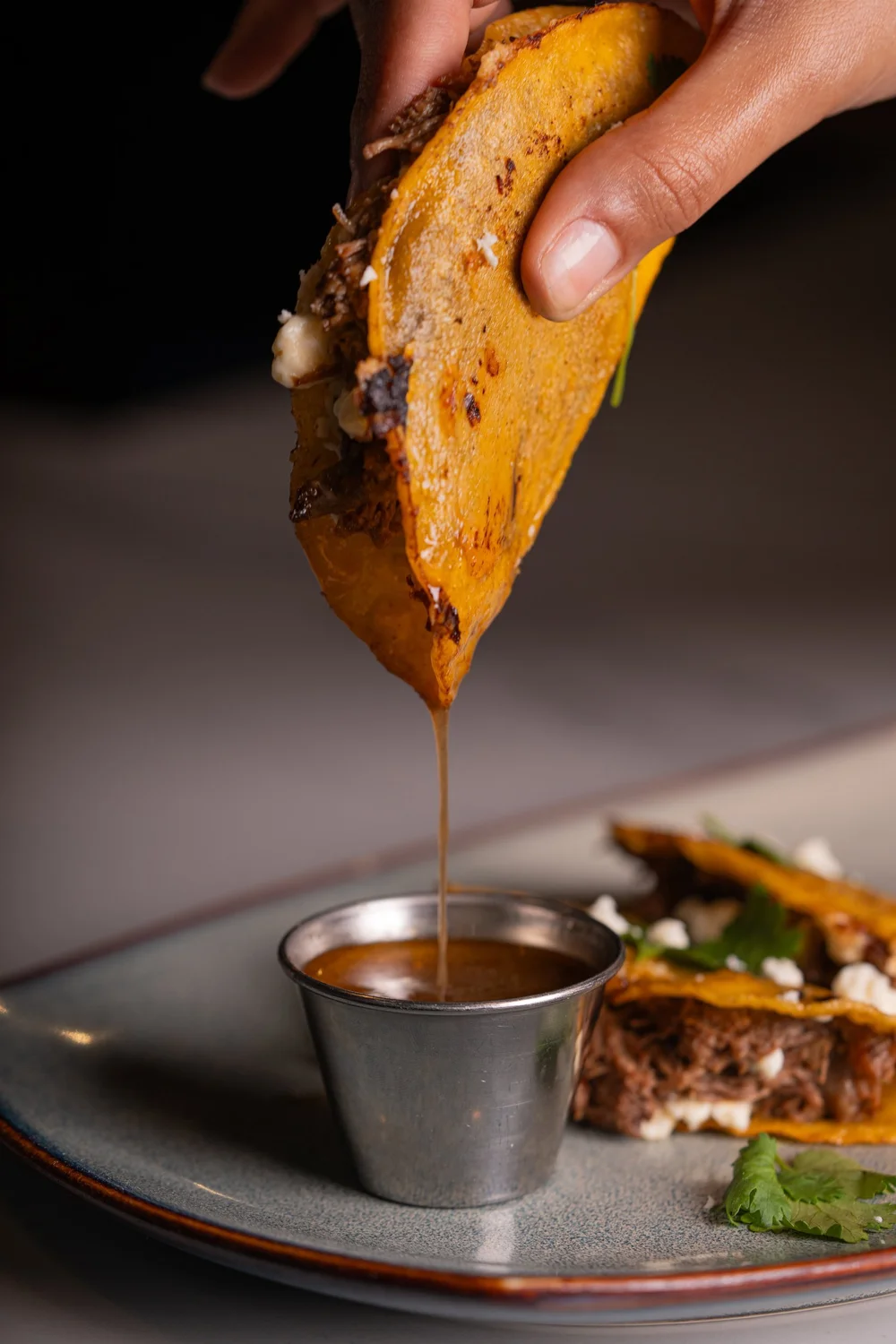 Birria tacos dipped in consommé at The Night Before